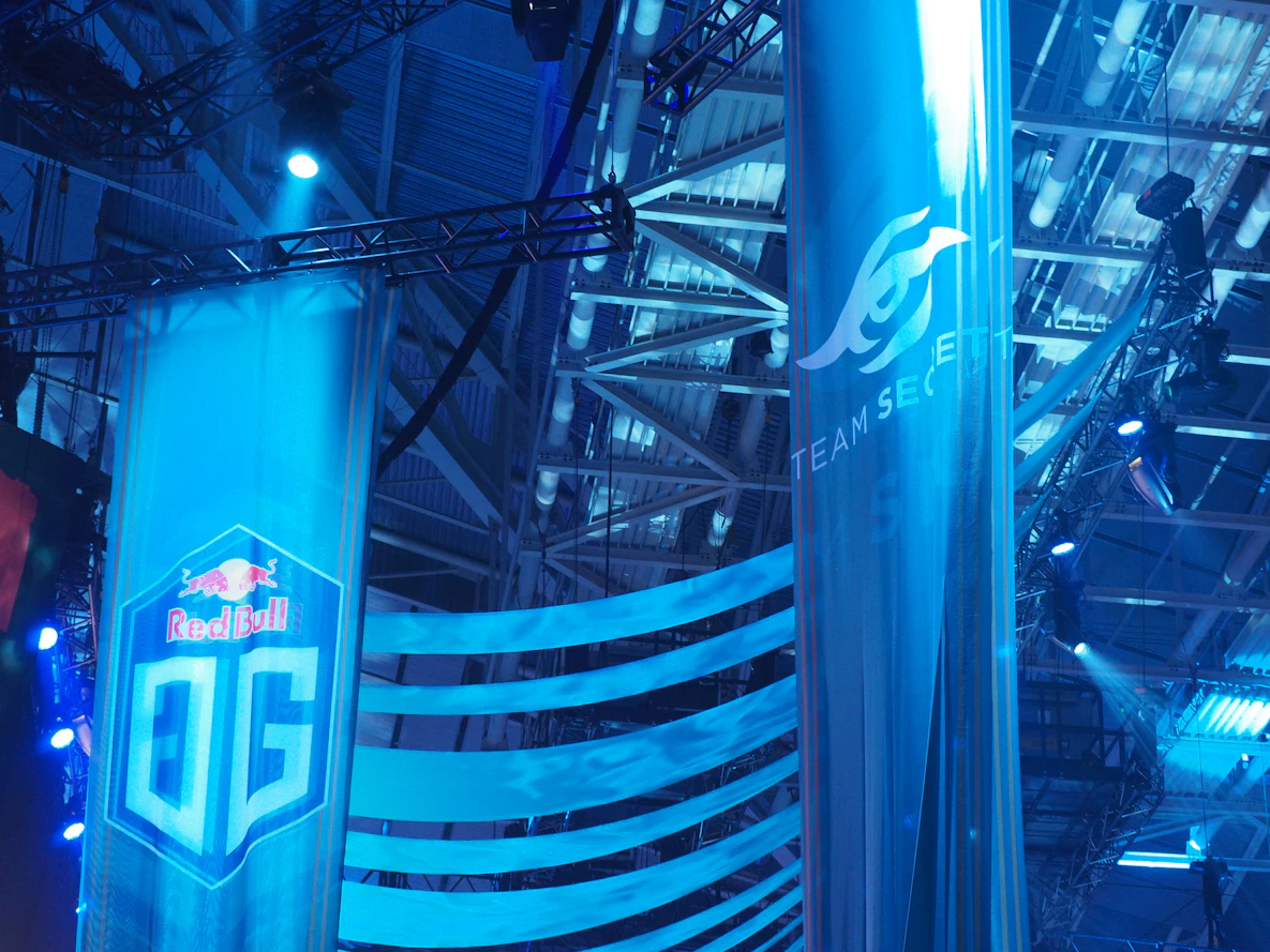 Banderolas azules con logotipos de equipos colgando en un evento de esports. Foto de Unsplash