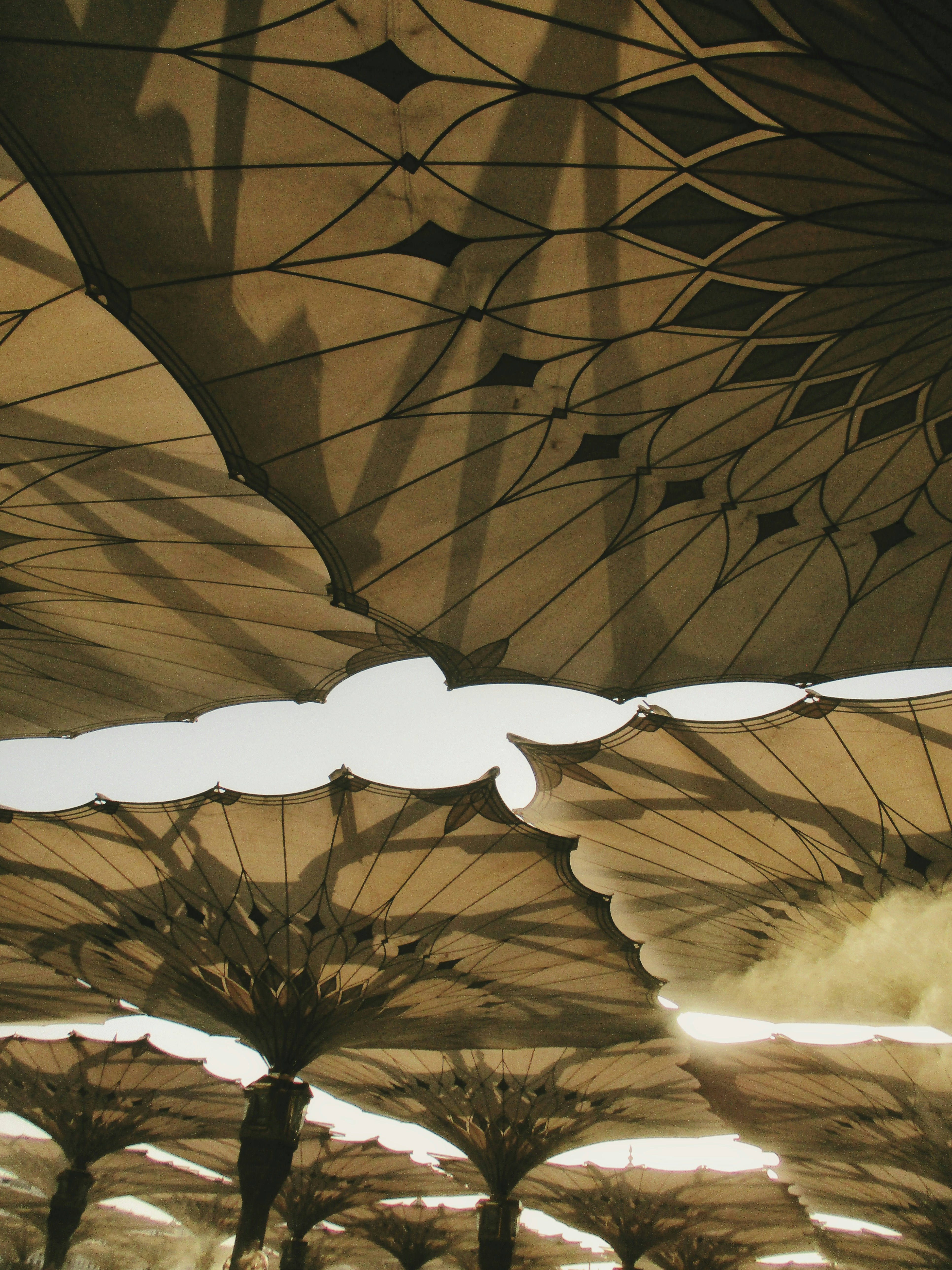 Large patterned umbrellas casting shadows against sky