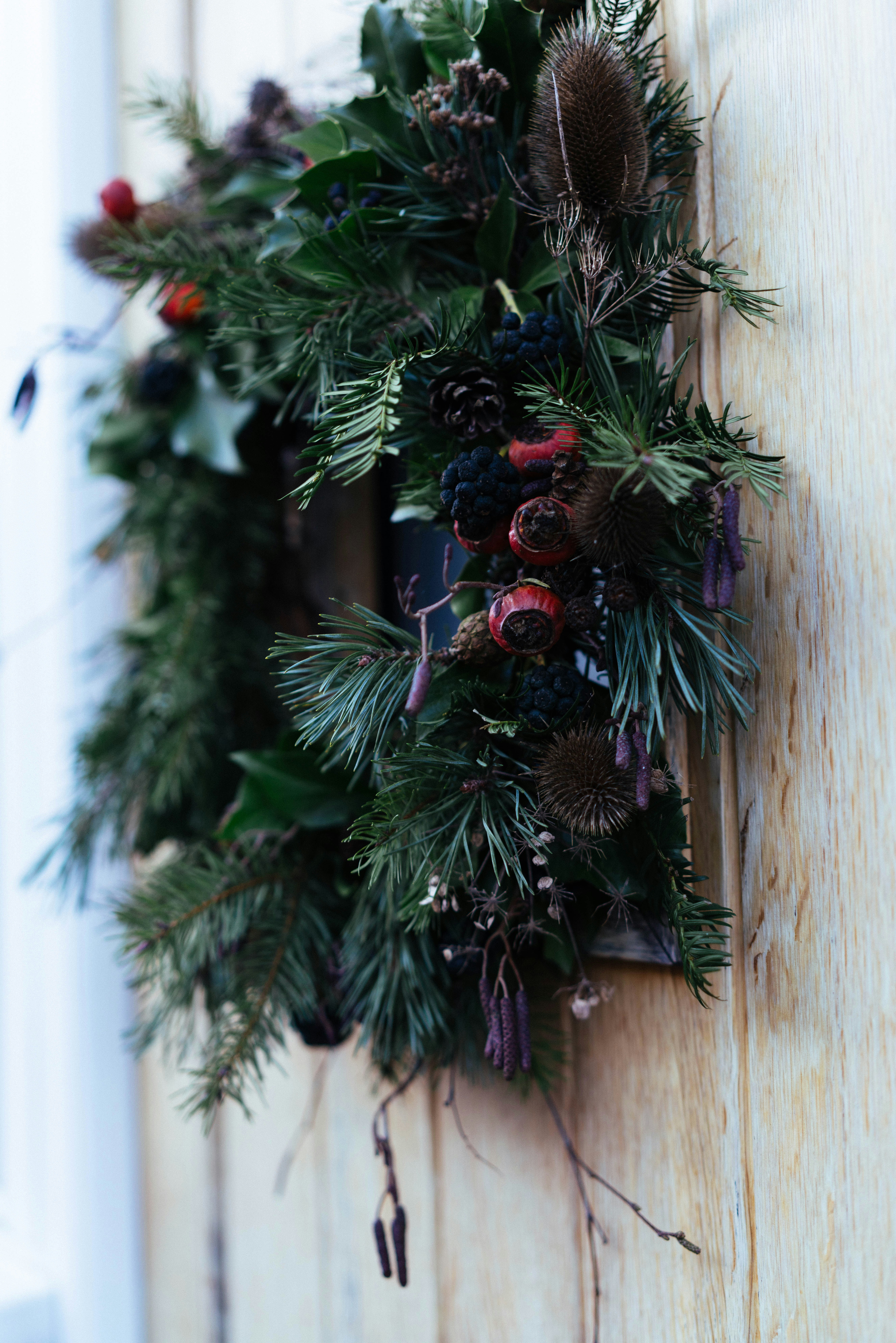 A rustic christmas wreath made of pine and berries.