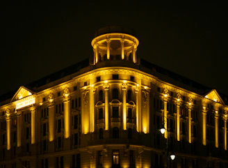 Ornate building illuminated with warm yellow lights at night.