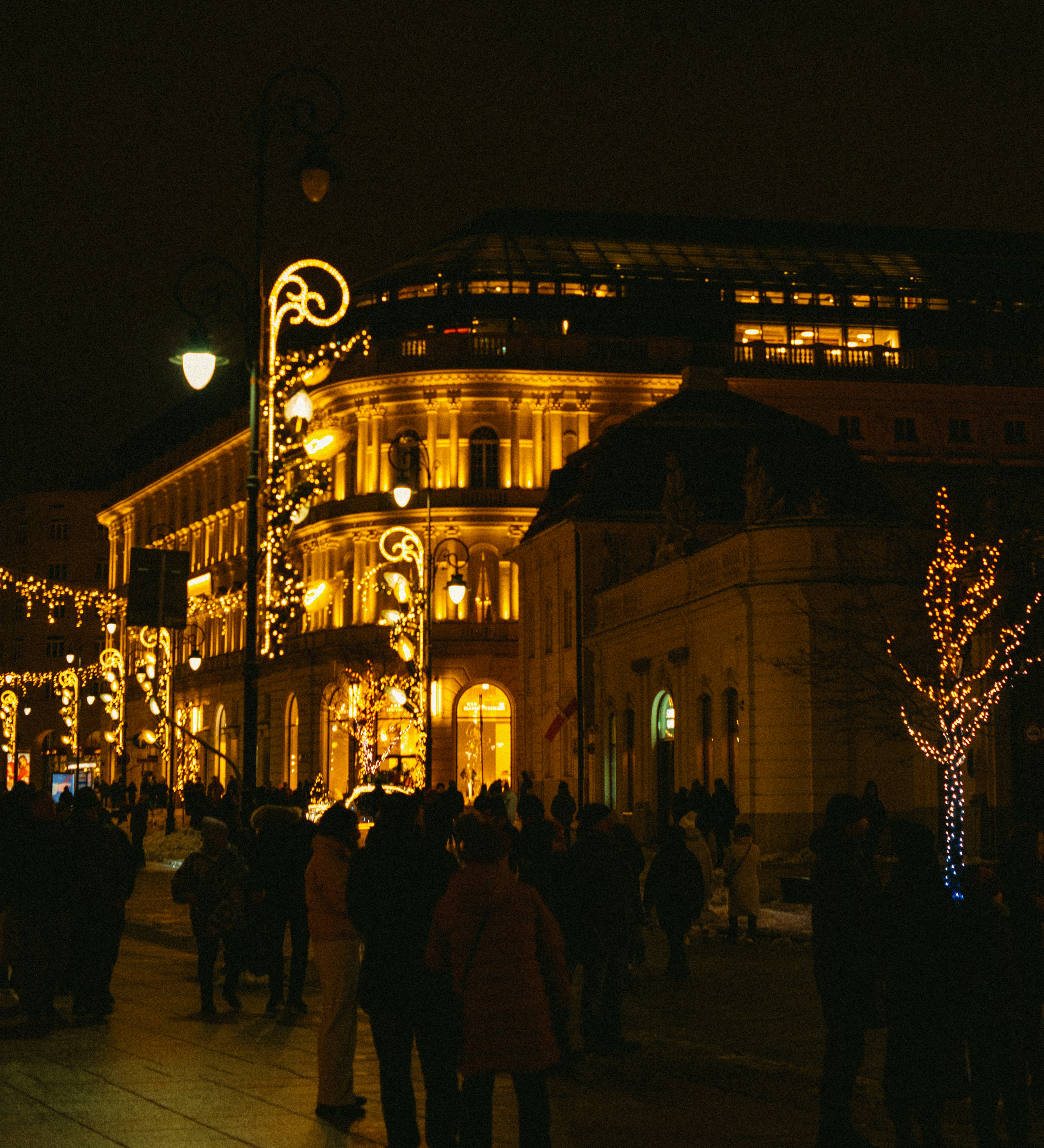 City street illuminated with festive christmas lights at night.