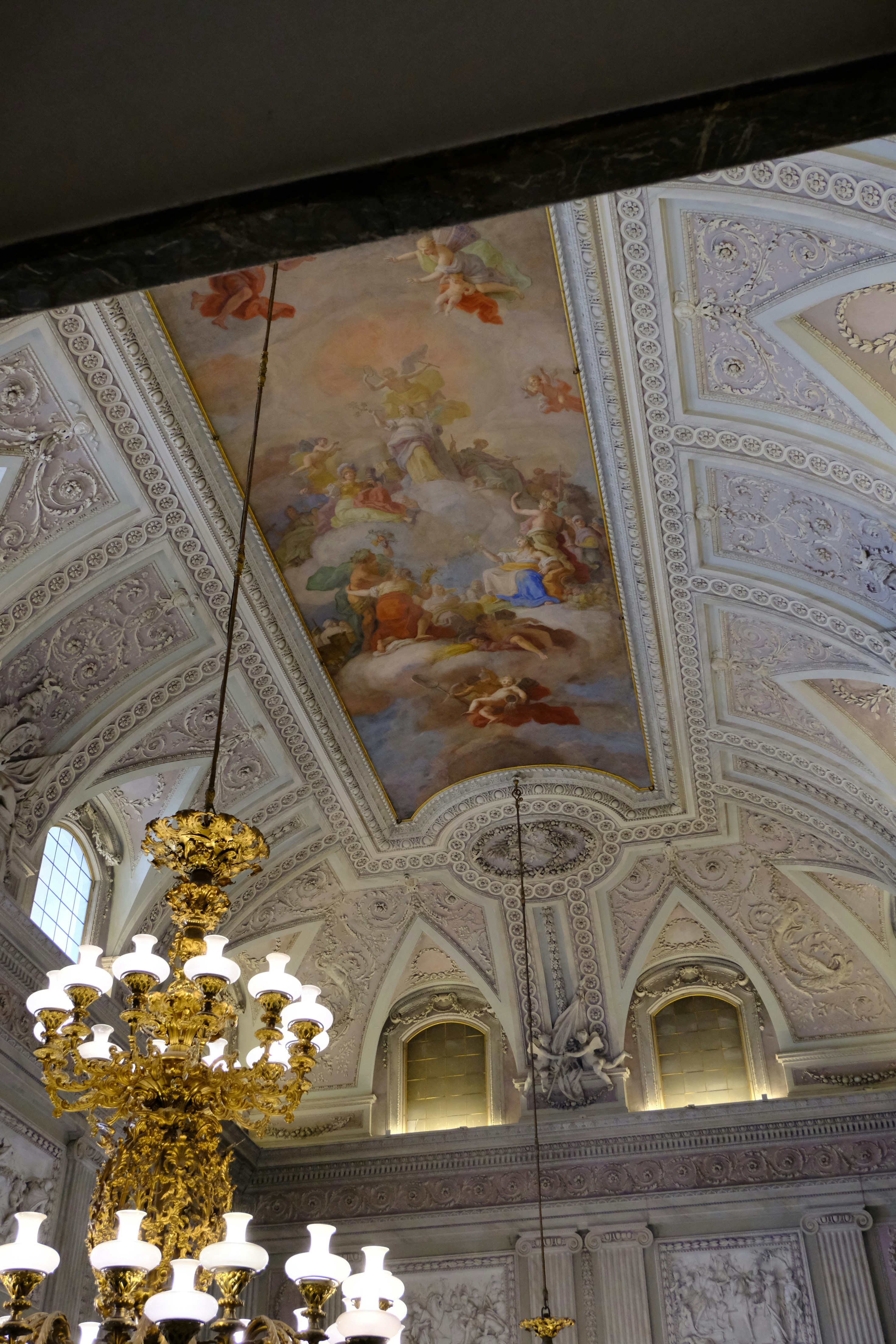 Ornate ceiling fresco with cherubs and chandeliers.