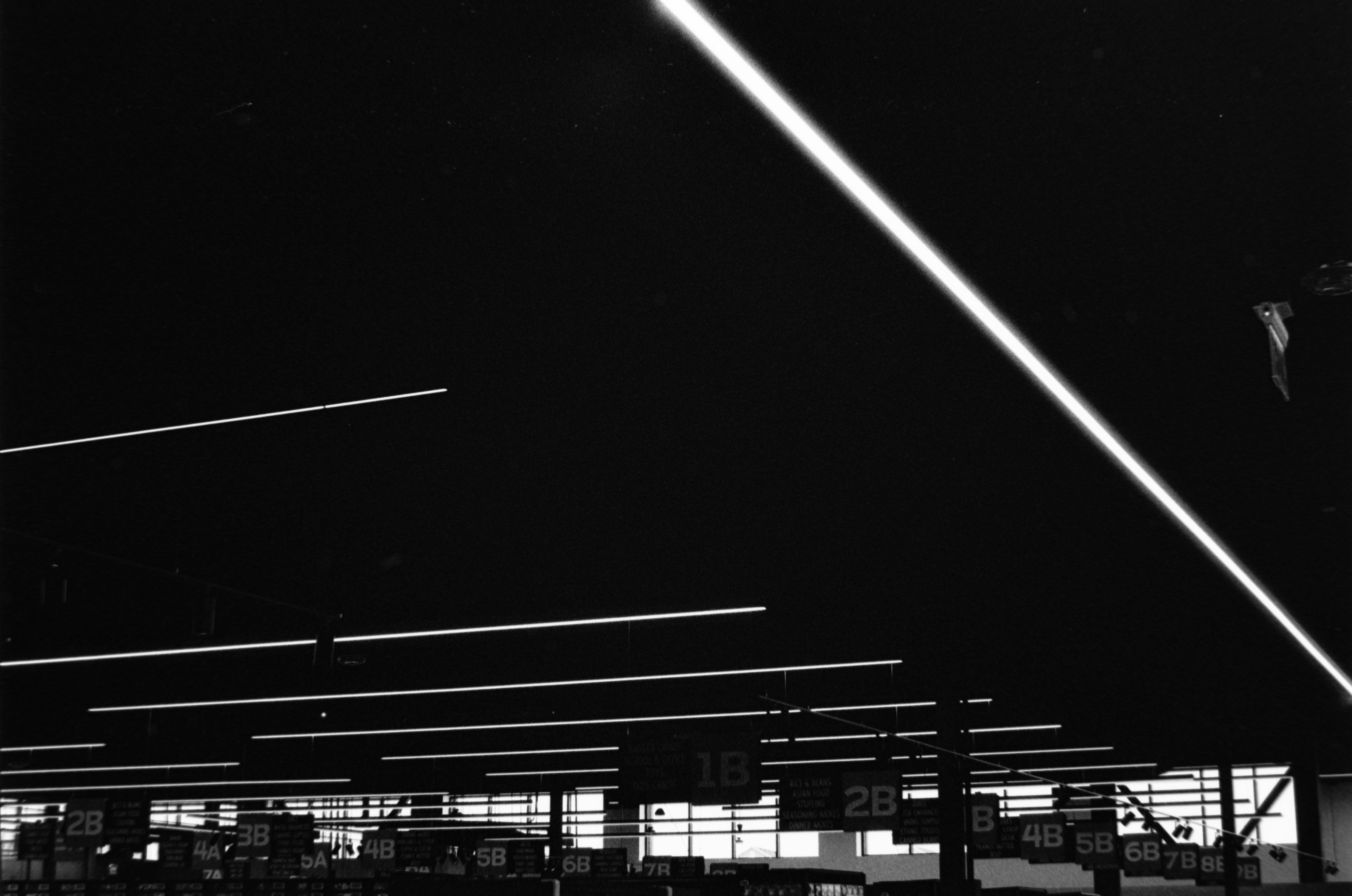 Fluorescent lights illuminate a dark ceiling and interior.