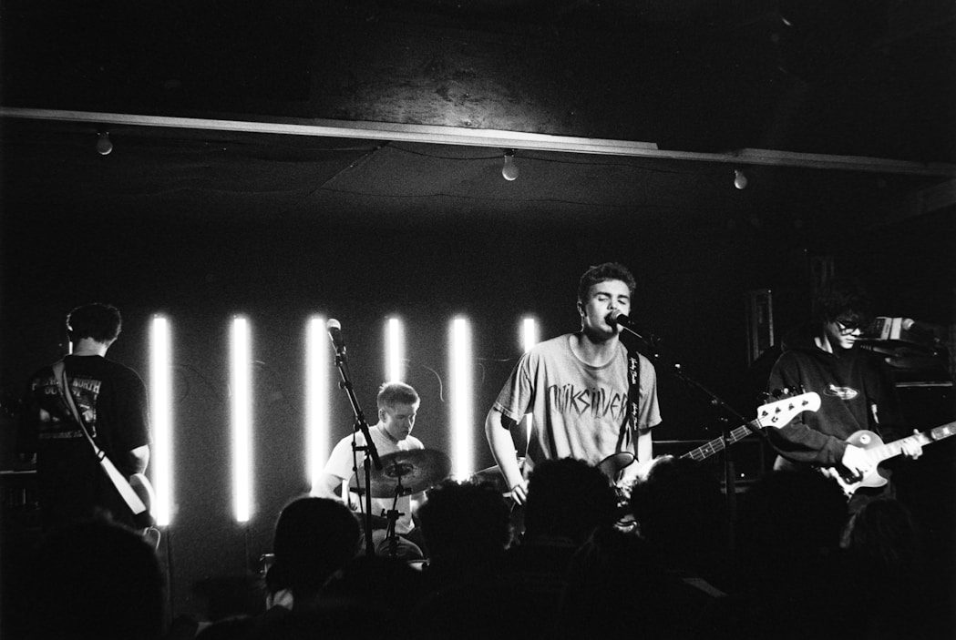 A band performs on stage with bright lights