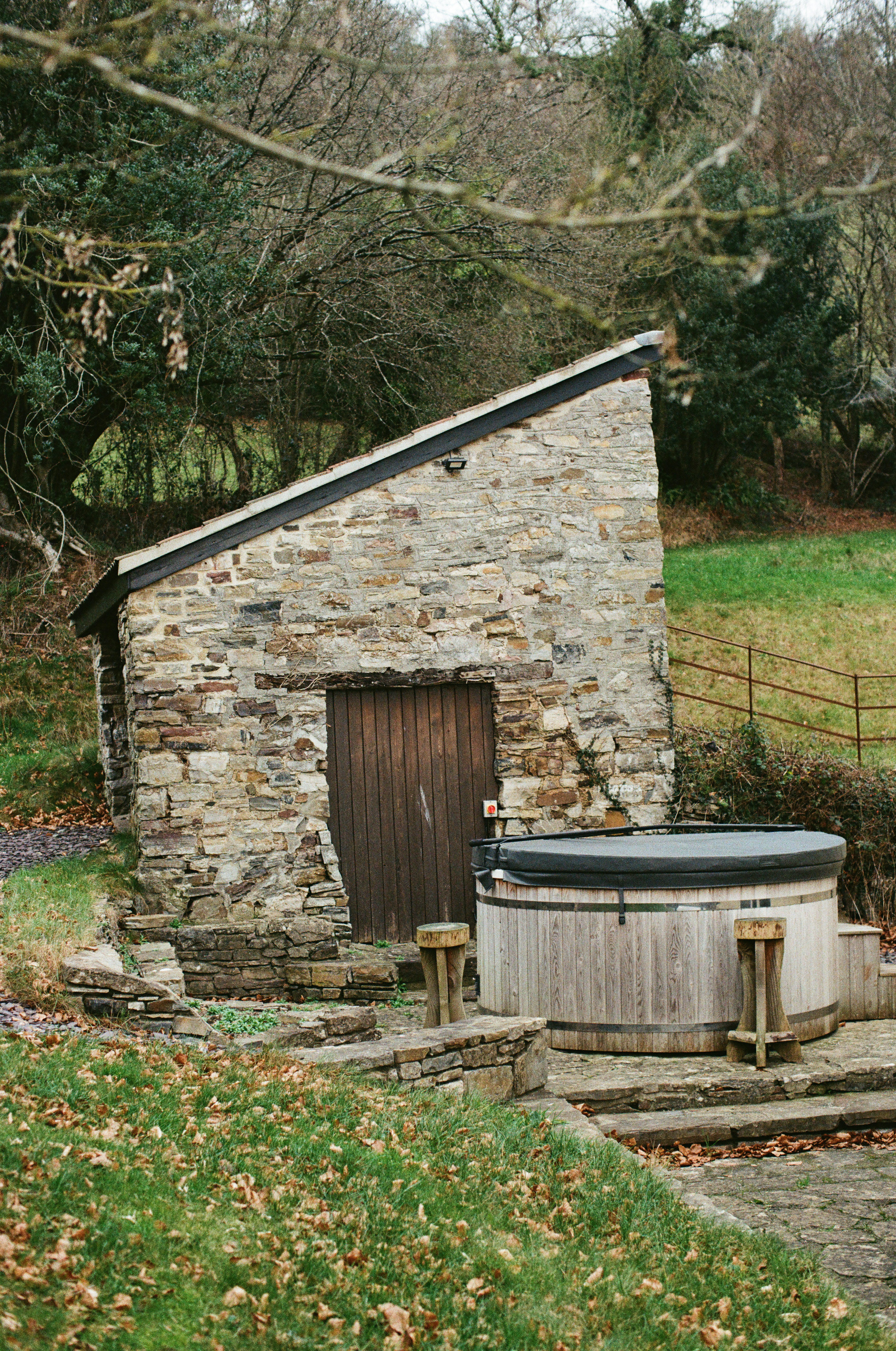 Steingebäude mit einem hölzernen Whirlpool draußen