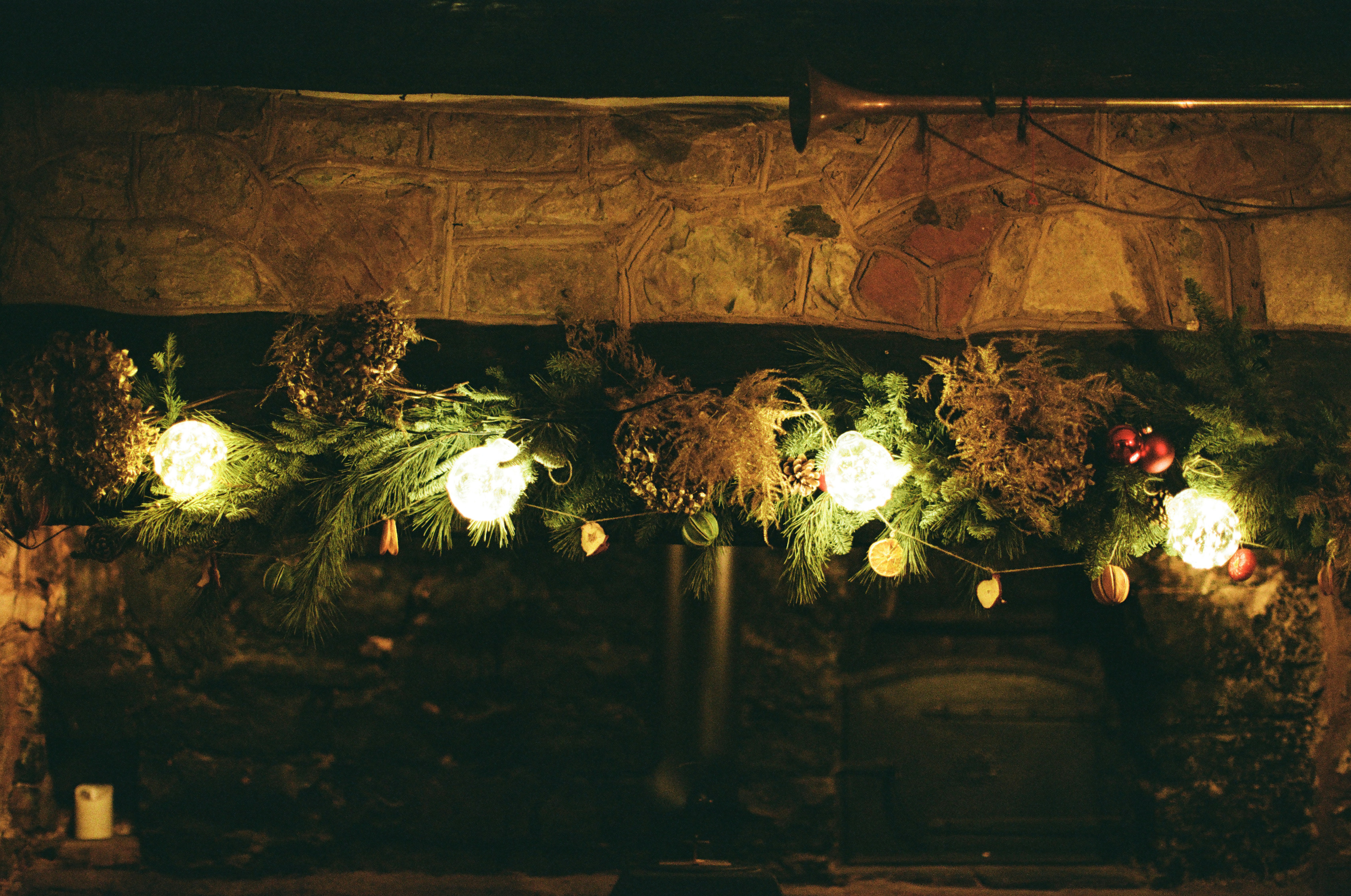 Christmas garland with lights above a fireplace.