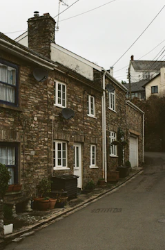 satellite dishes attached to stone houses which line a narrow, uphill street in lewes