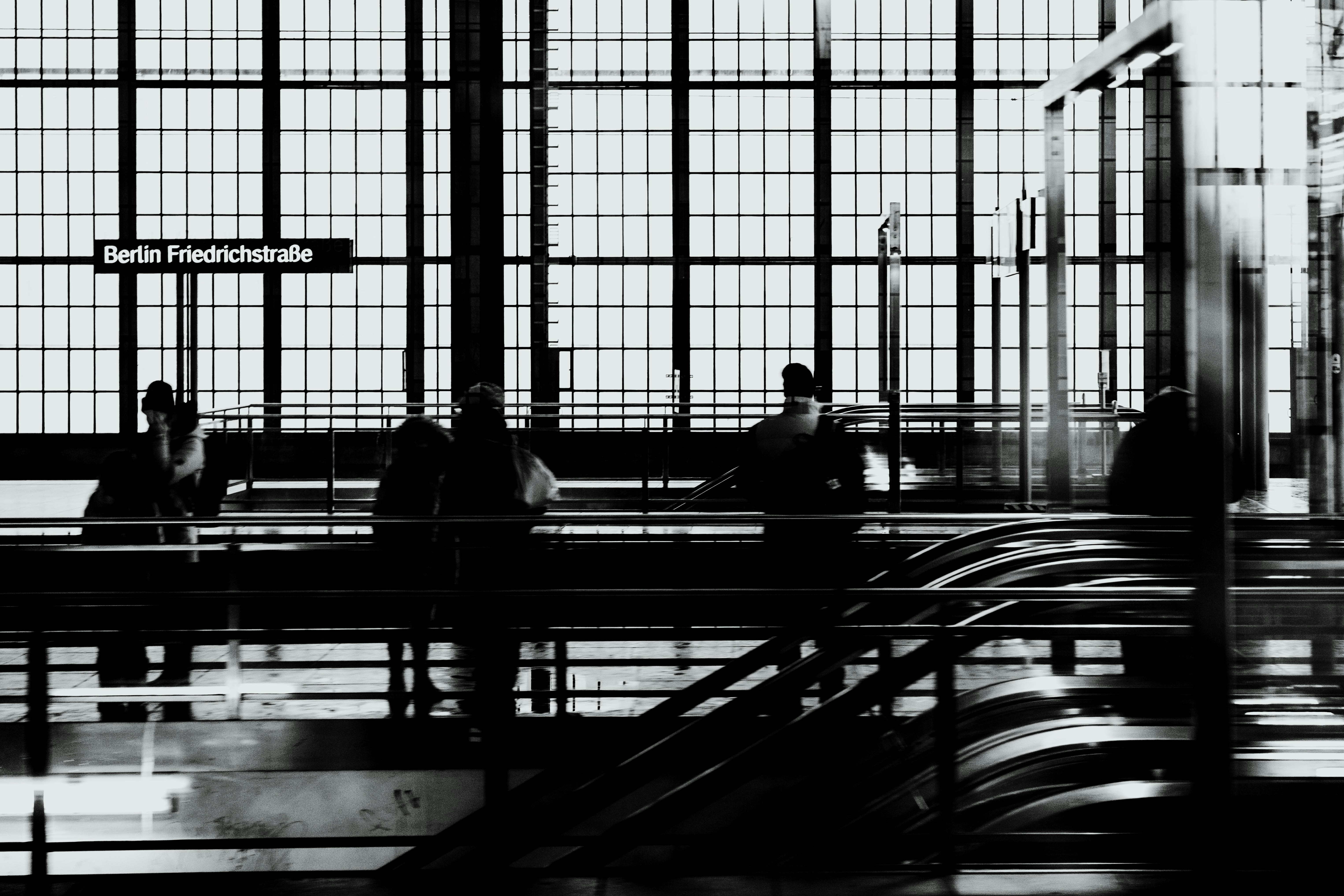 People on a train platform with large windows