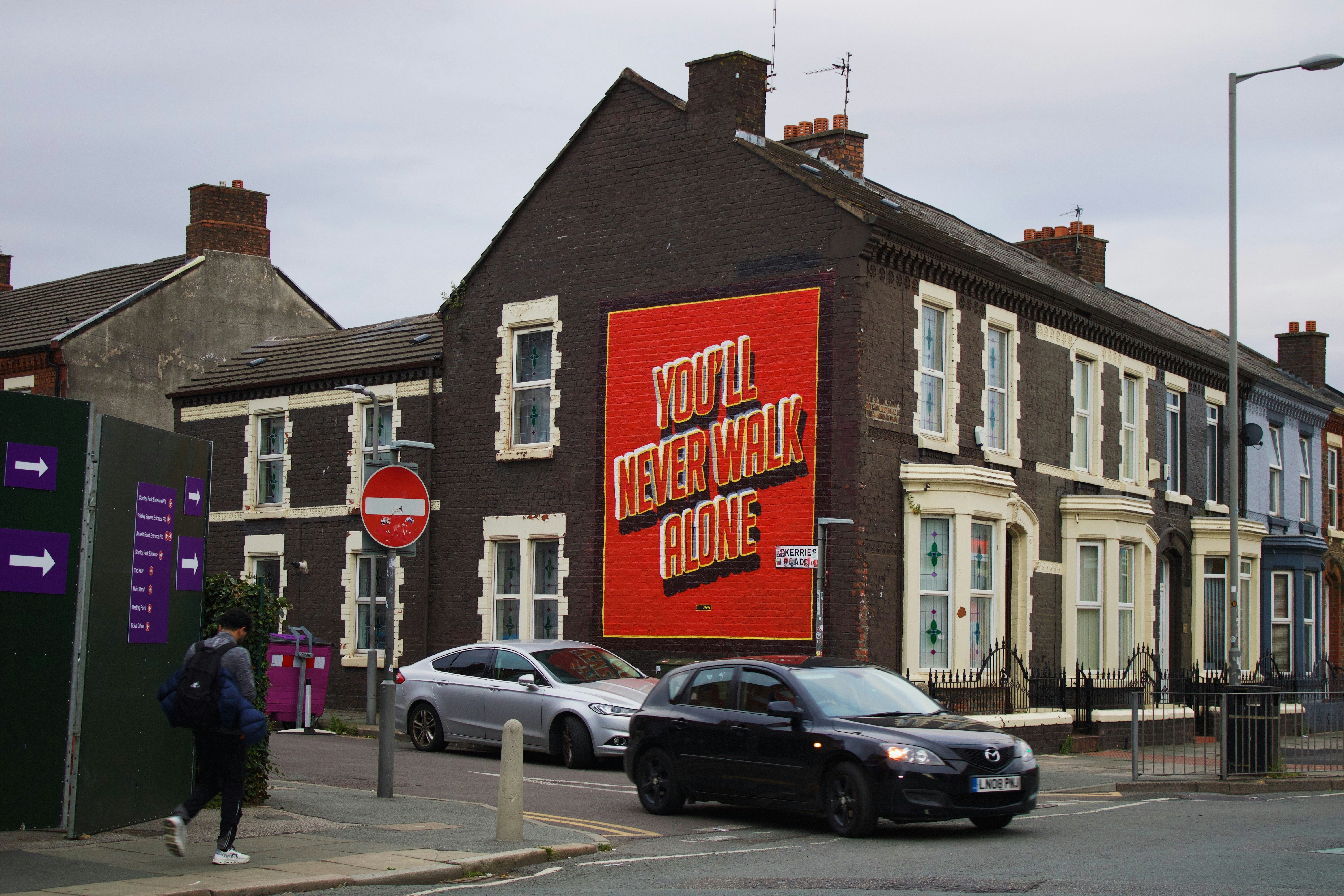 Building with large red sign and cars on street