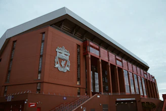 Exterior of a large brick stadium with a crest