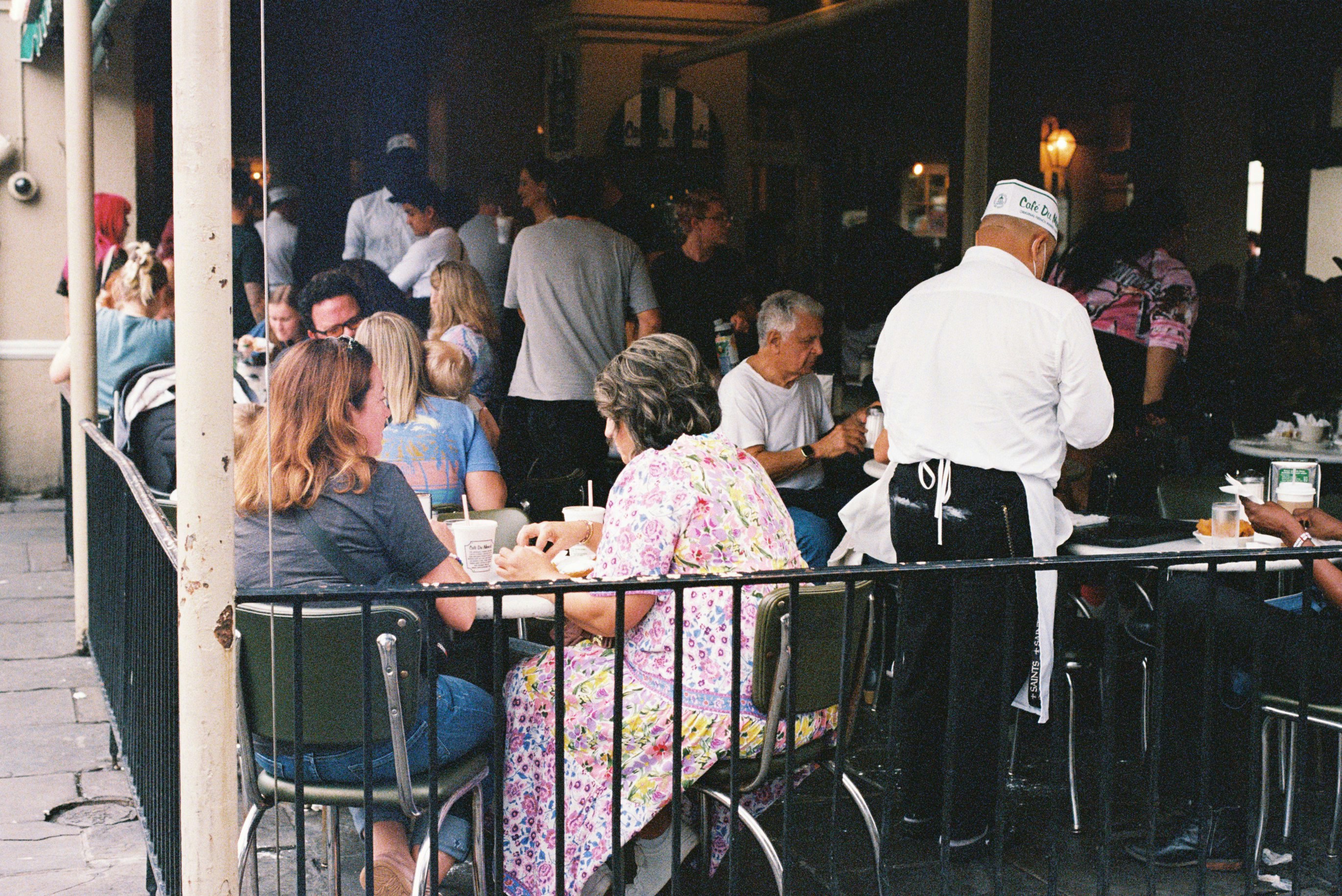 People dining on an outdoor restaurant patio at night.