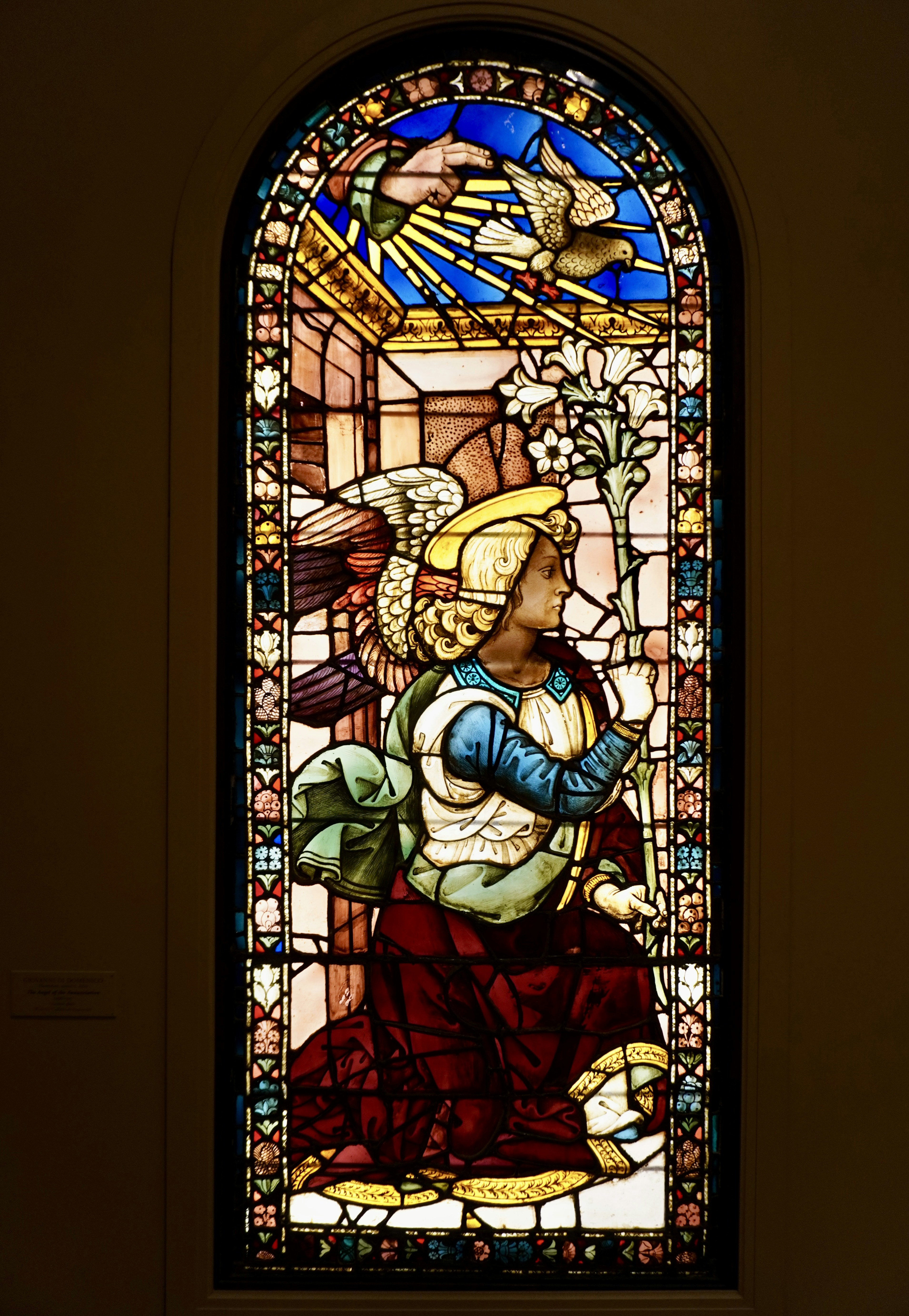 Stained glass window depicting an angel with lilies