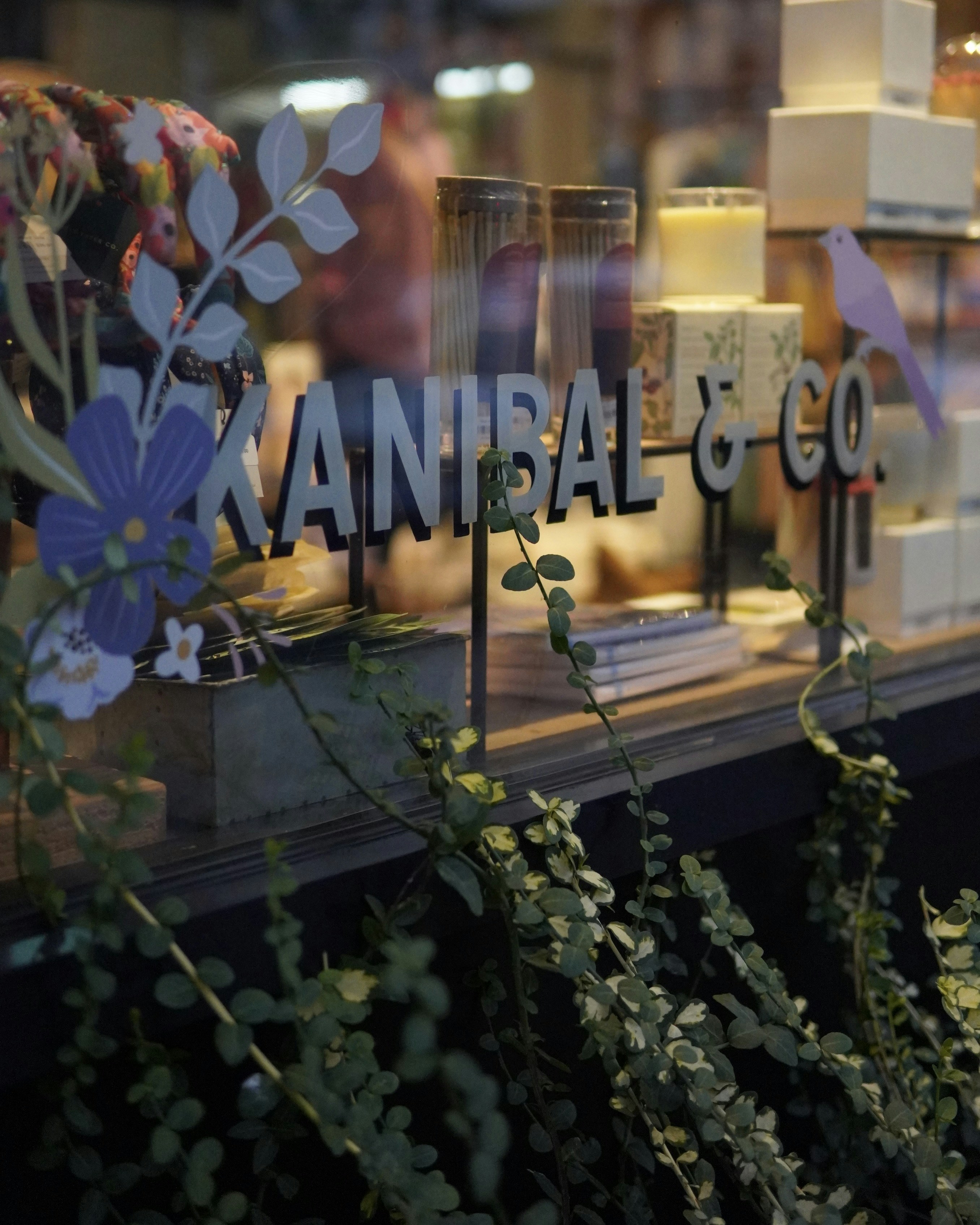 Shop window display with candles and flowers.