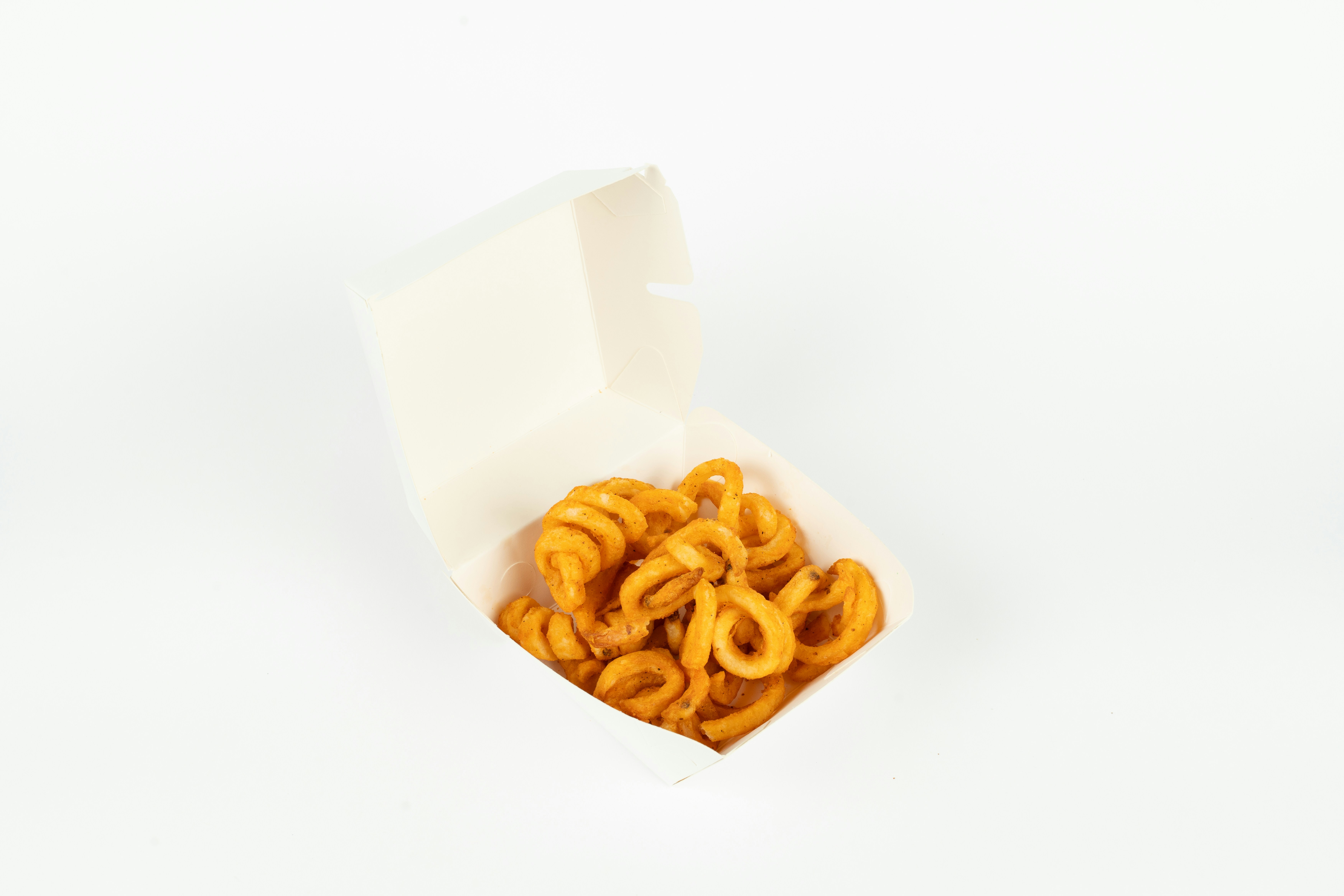 Curly fries in a white takeout box