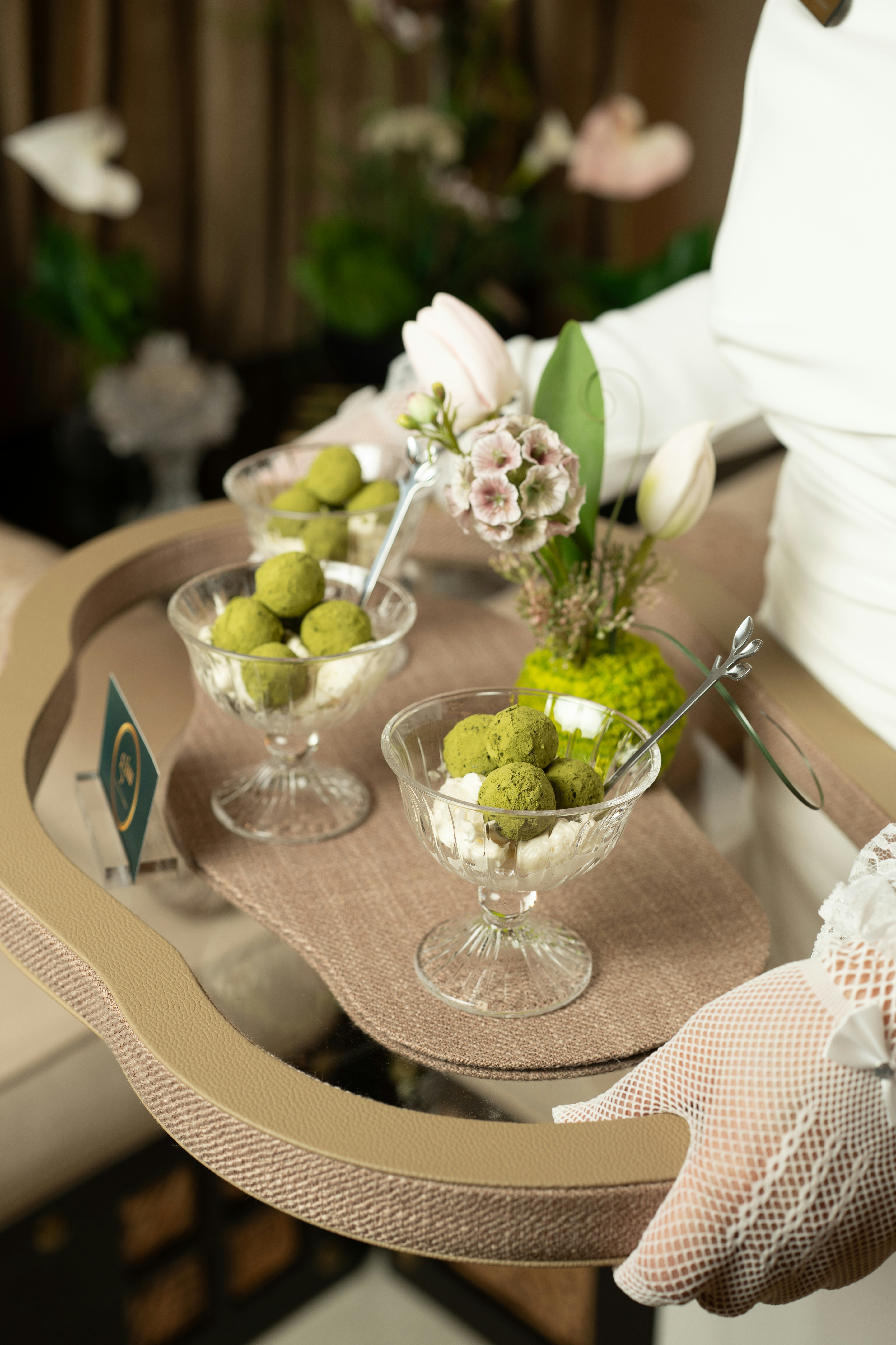 Green dessert balls served in glasses on a tray