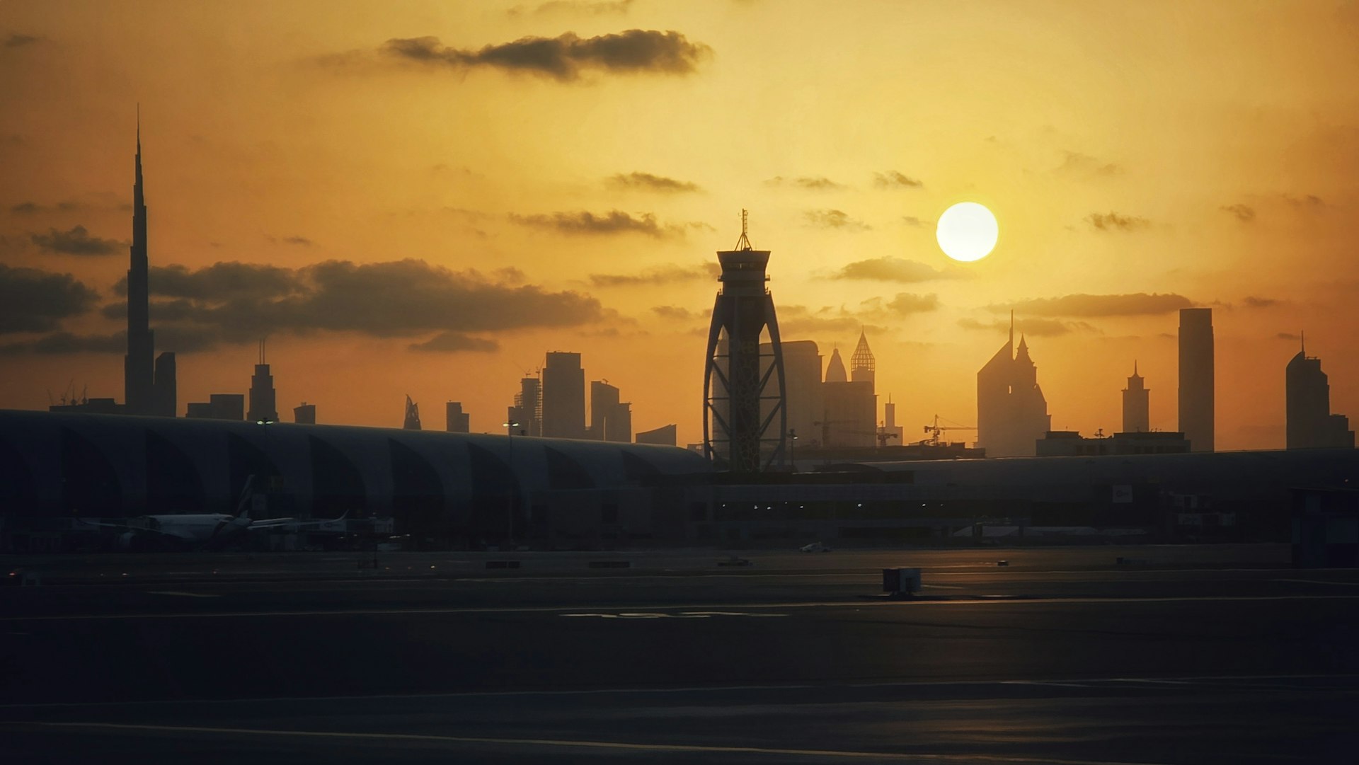 City skyline silhouetted against a dramatic sunset.