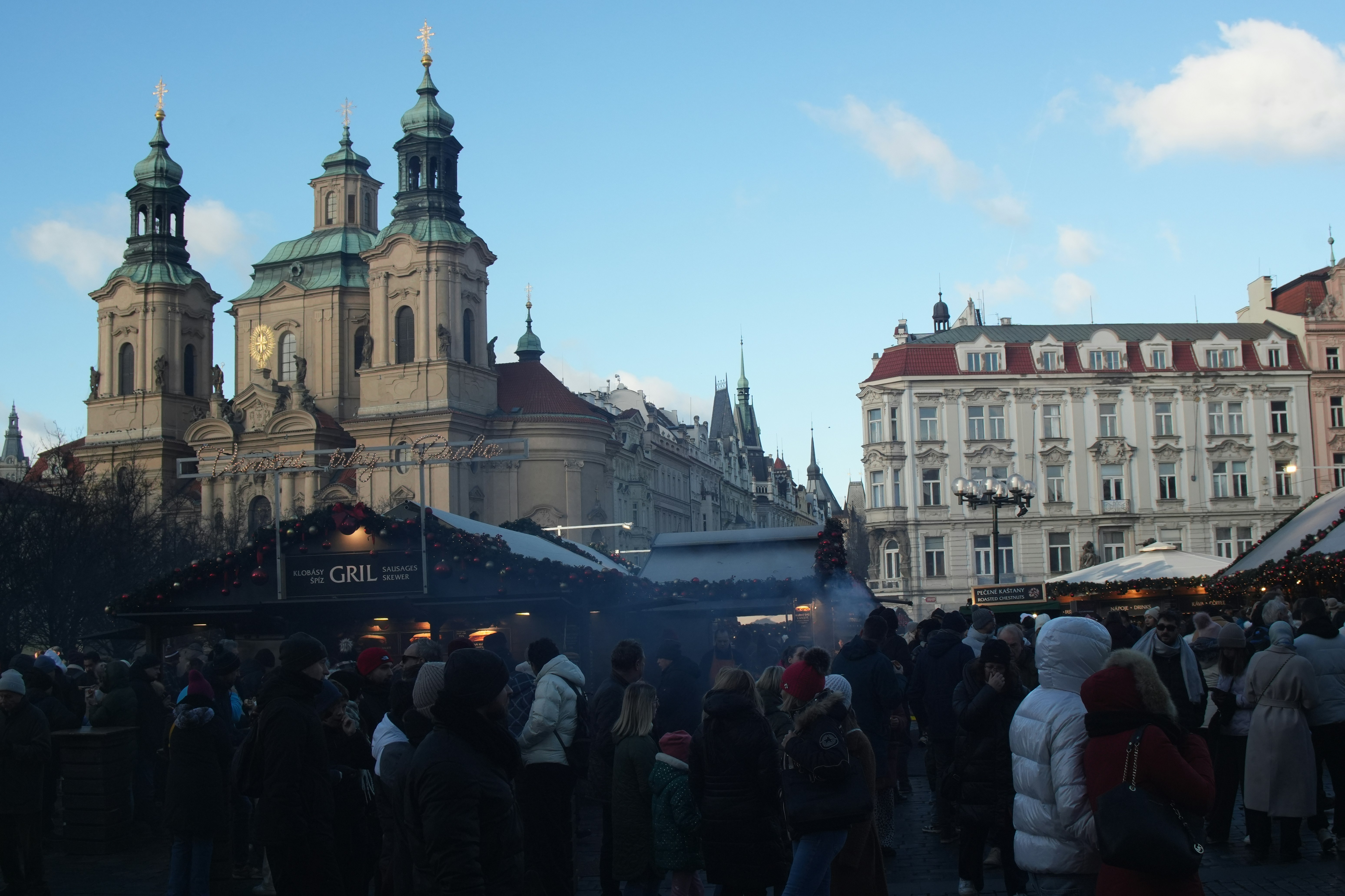 Crowded market square with historic buildings and people.