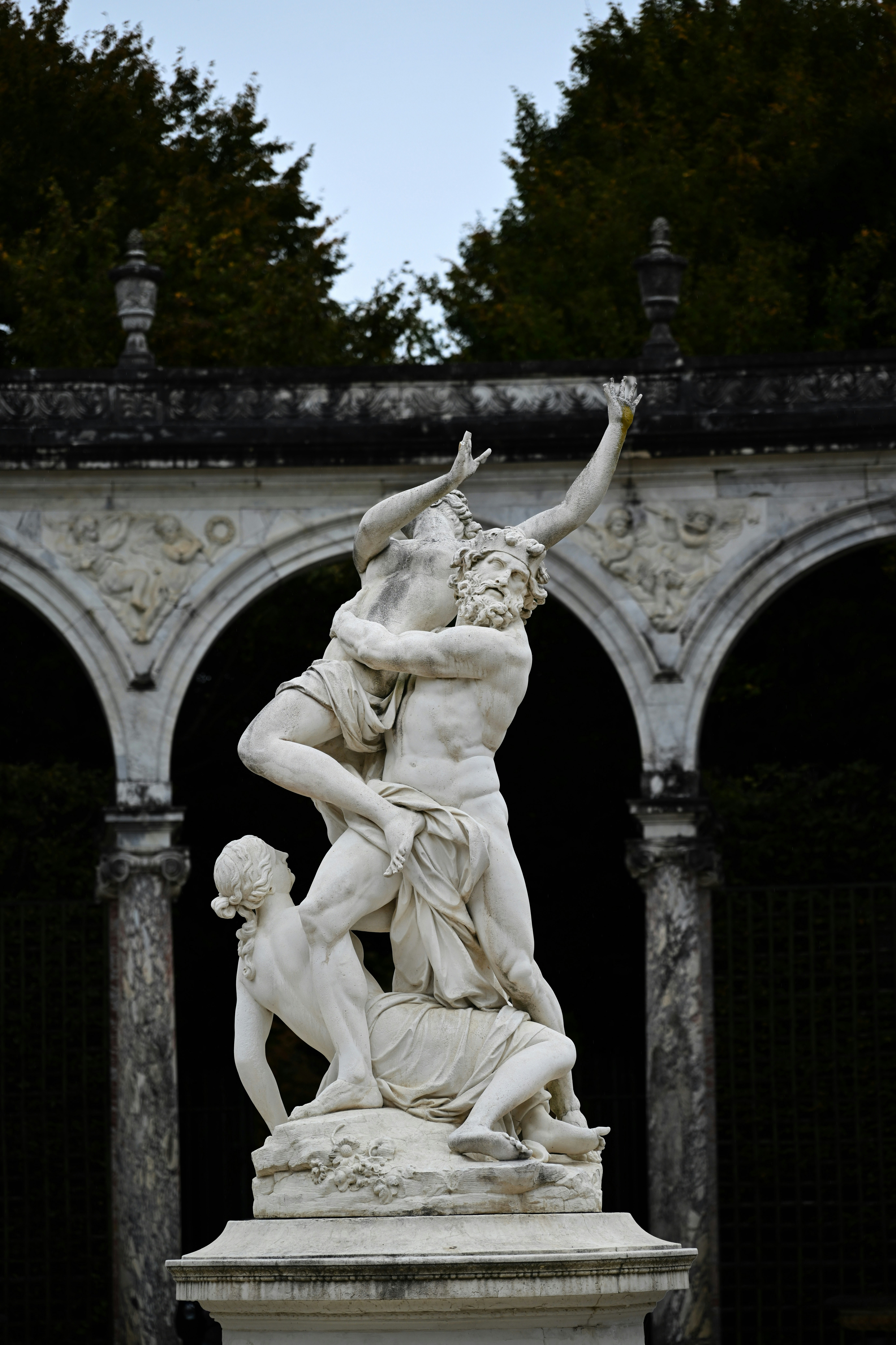 Marble sculpture of three figures in dramatic embrace