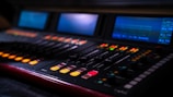A professional audio mixing console with illuminated buttons