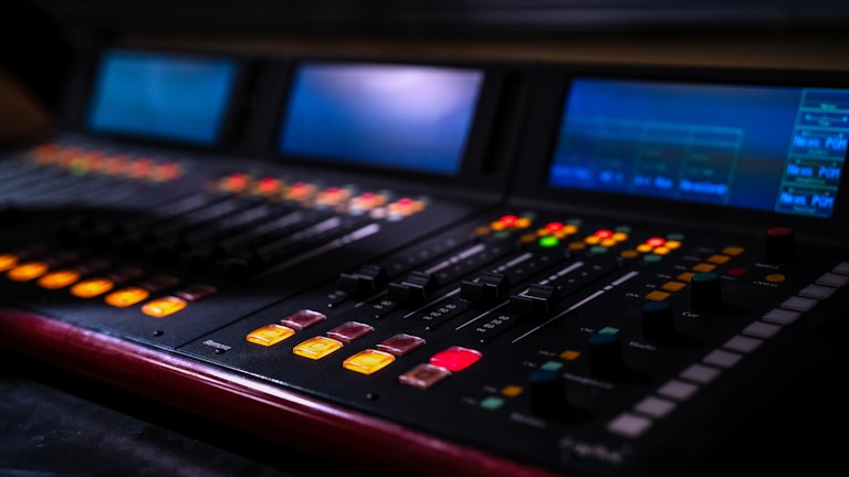 A professional audio mixing console with illuminated buttons