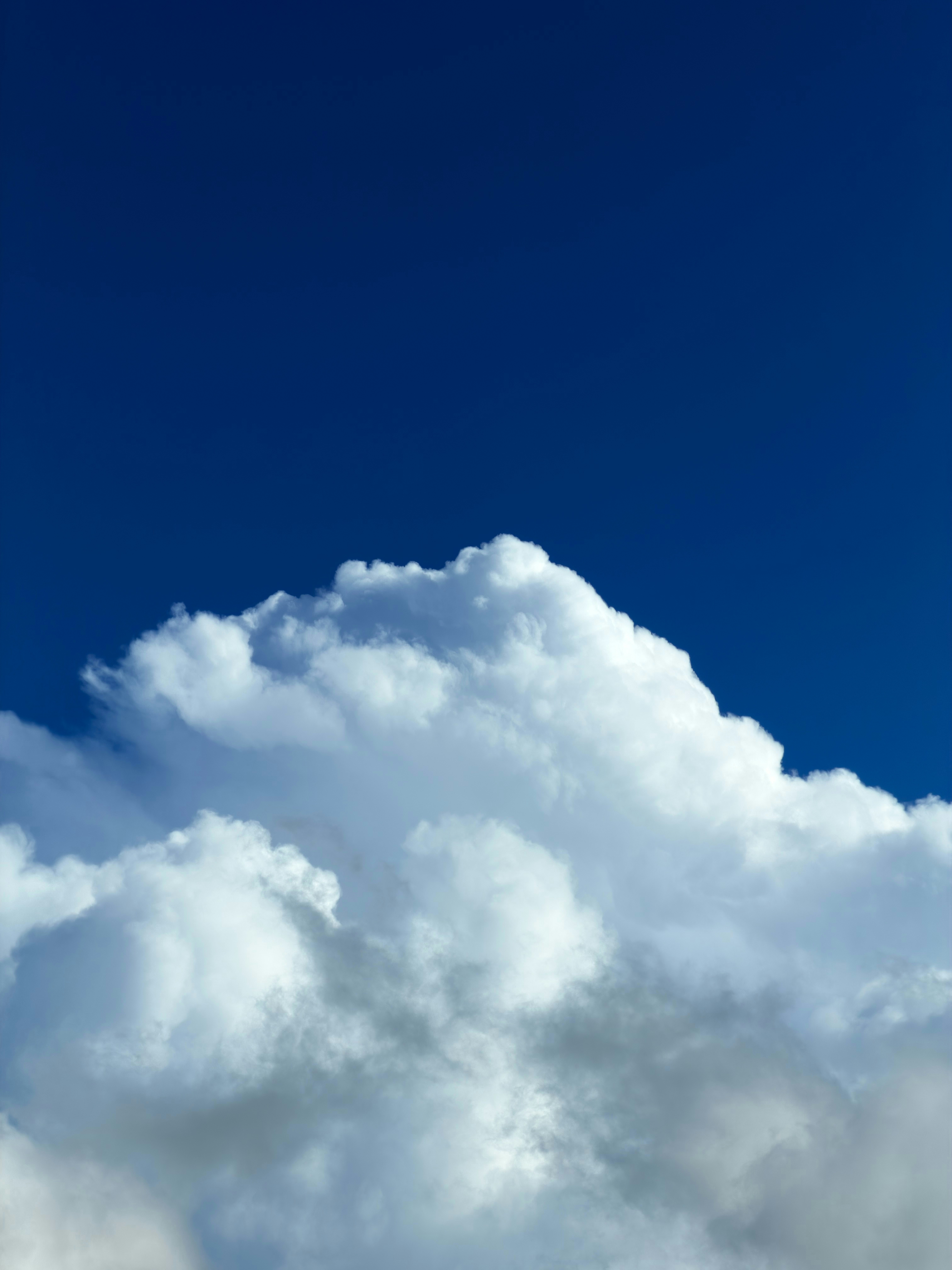 Fluffy white clouds against a deep blue sky.