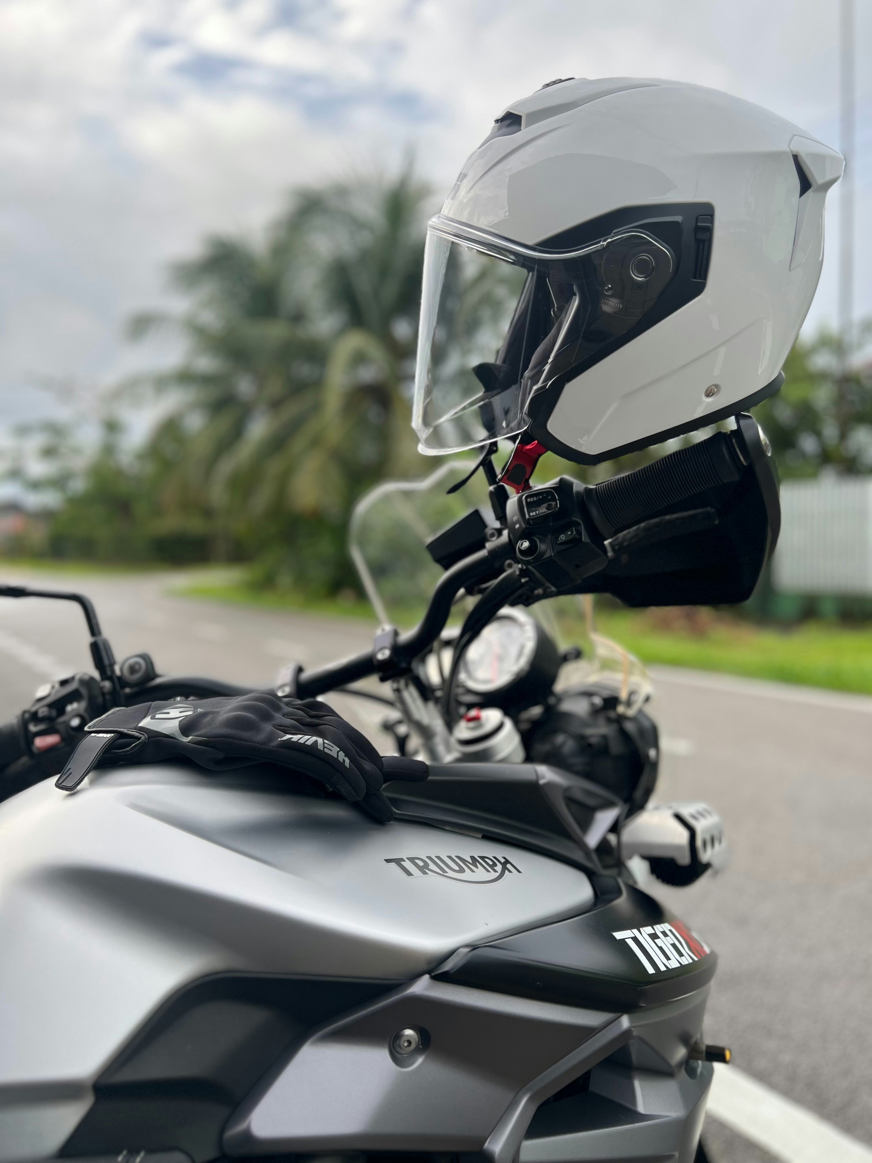 White motorcycle helmet on a silver triumph motorcycle.