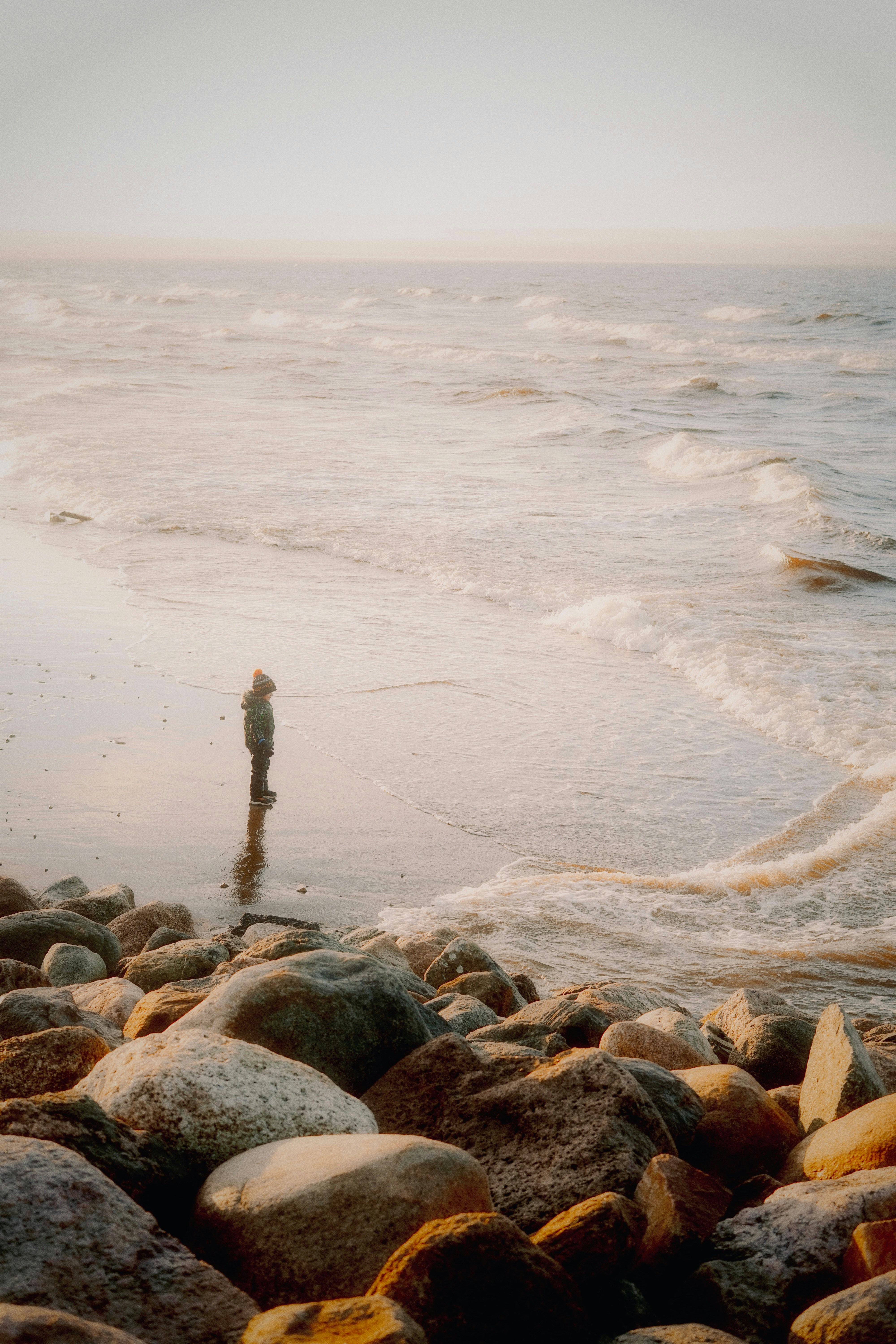 Person standing on a rocky beach by the ocean