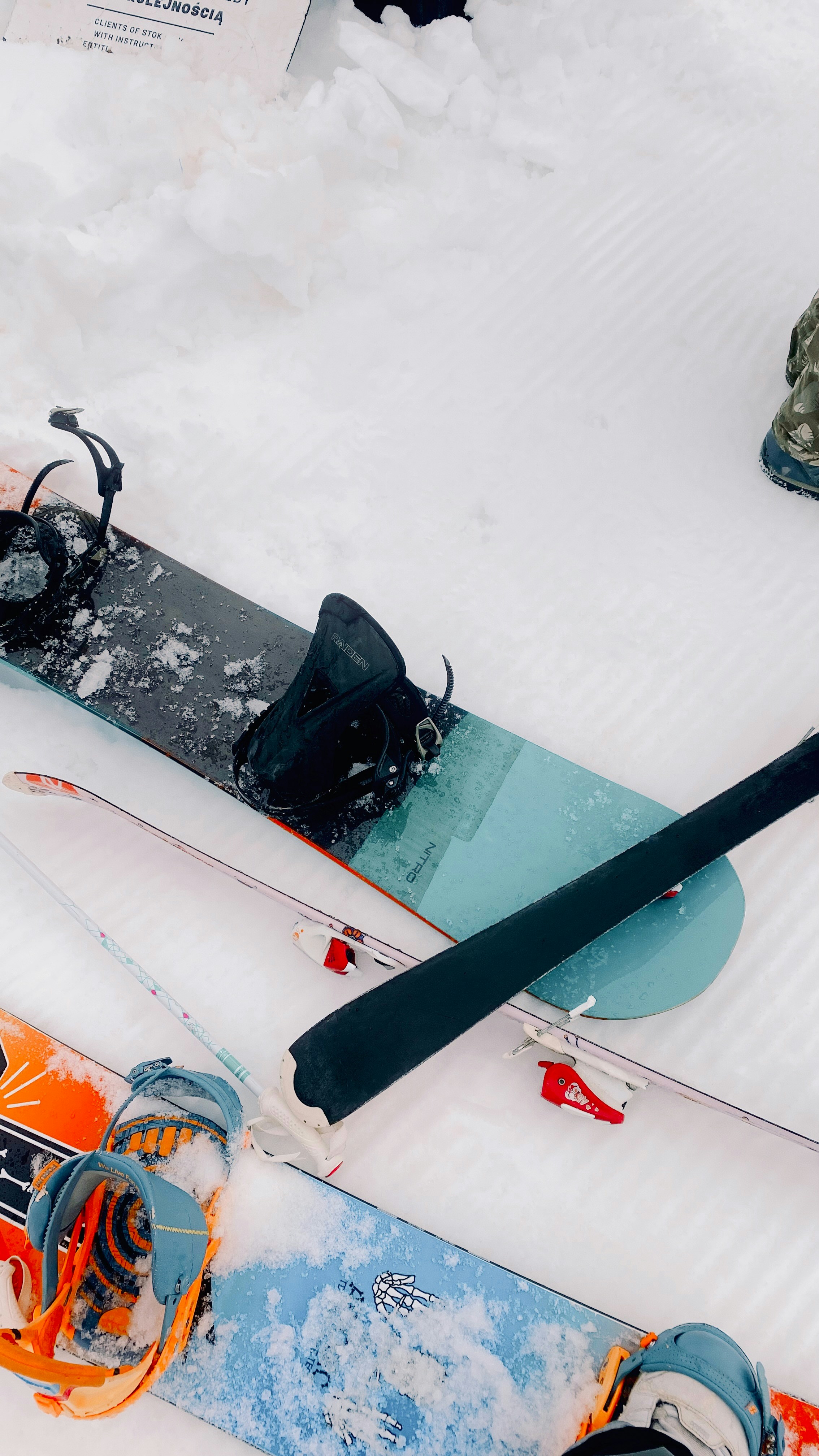 Snowboards and skis resting in the snow