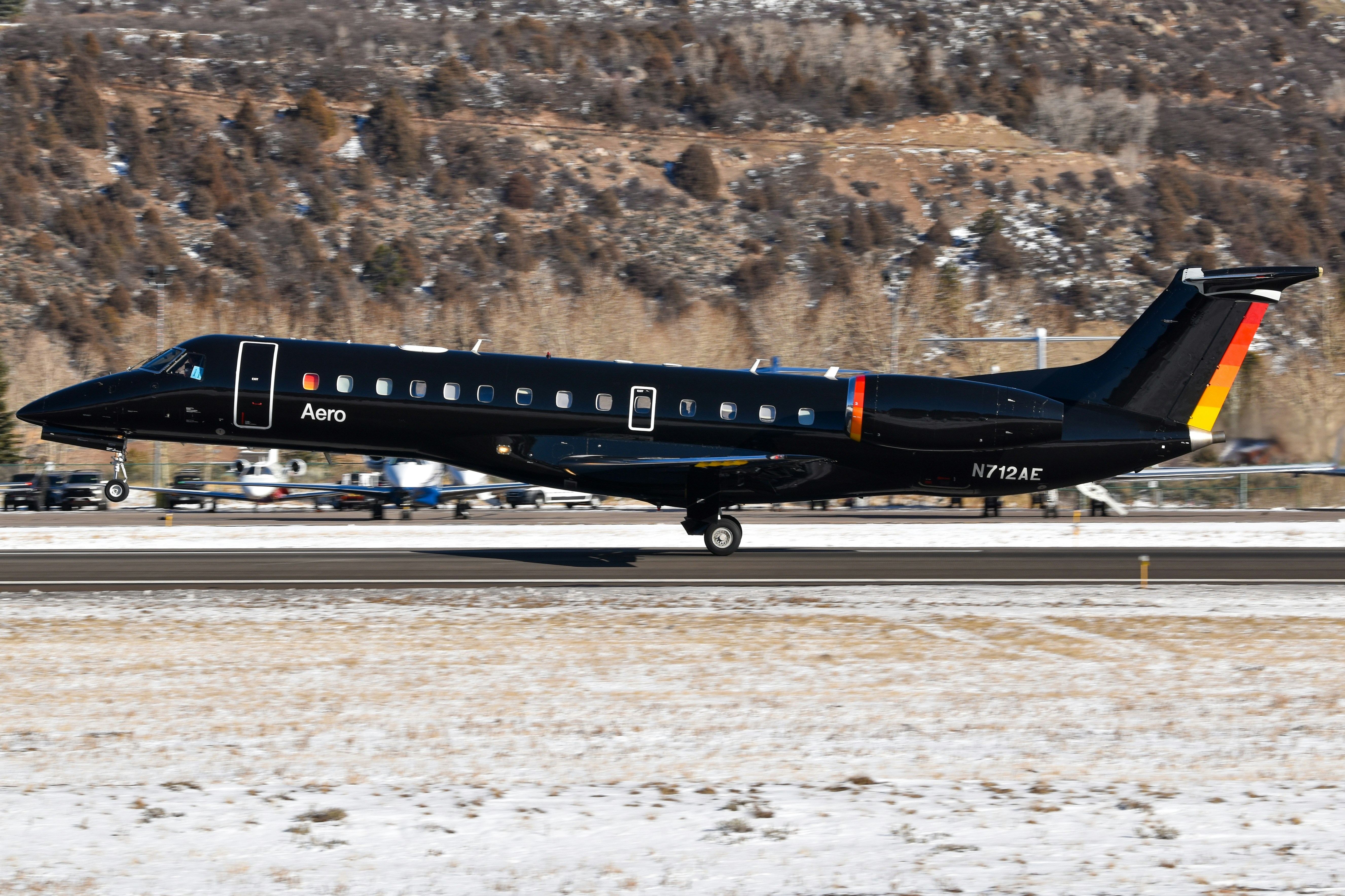 Un jet privado negro sobre una pista nevada.