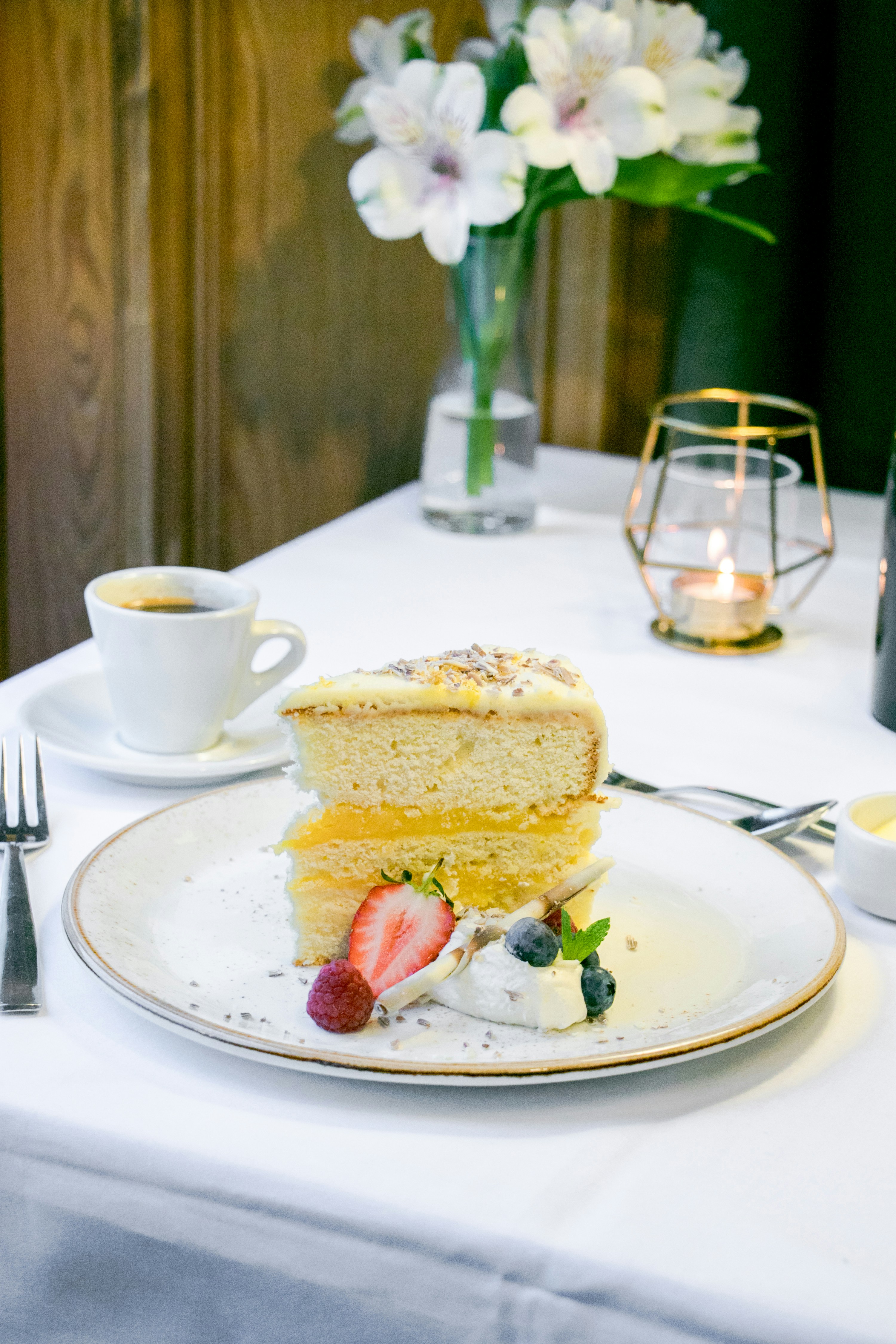 A slice of cake with berries and coffee