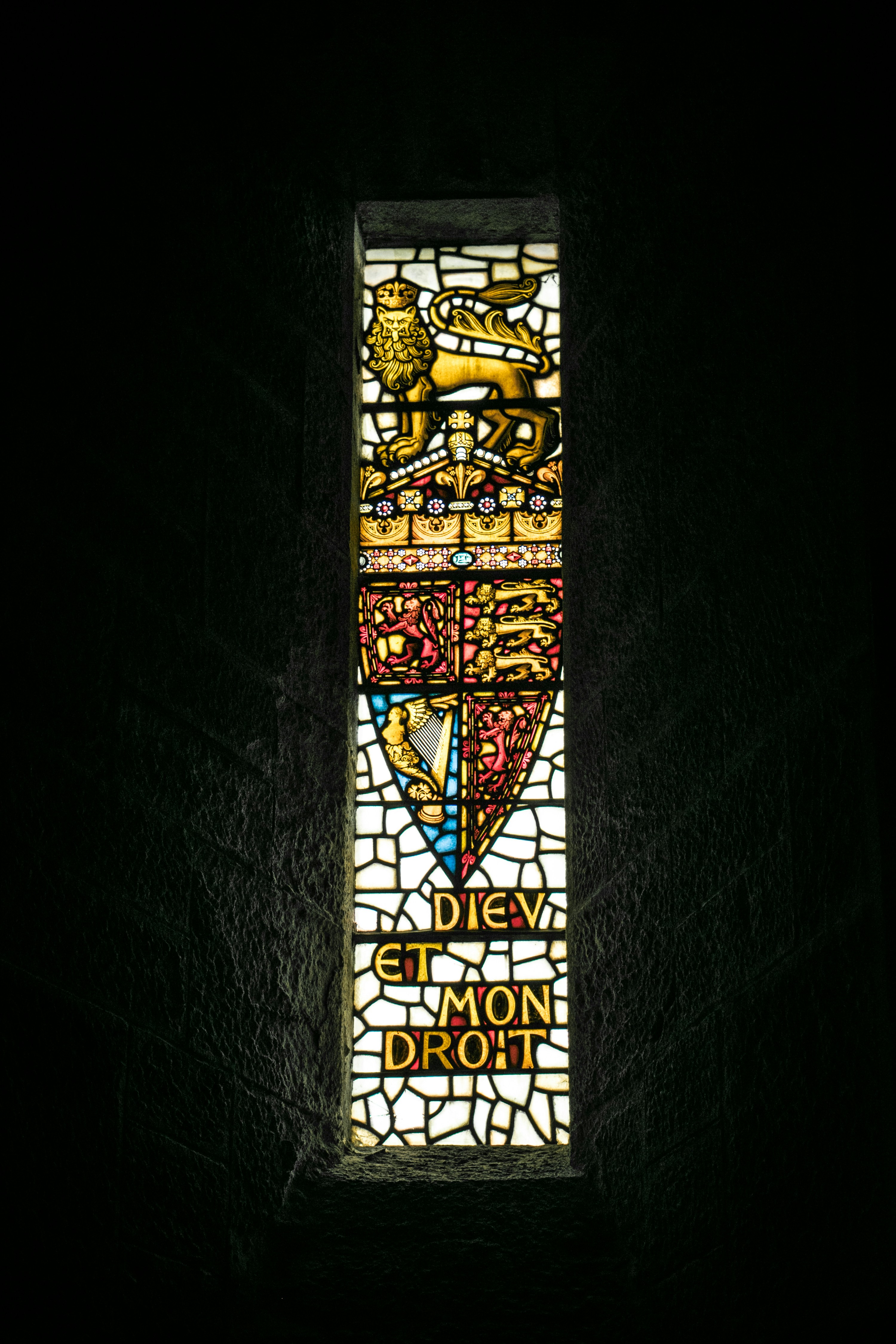Stained glass window with royal crest and motto