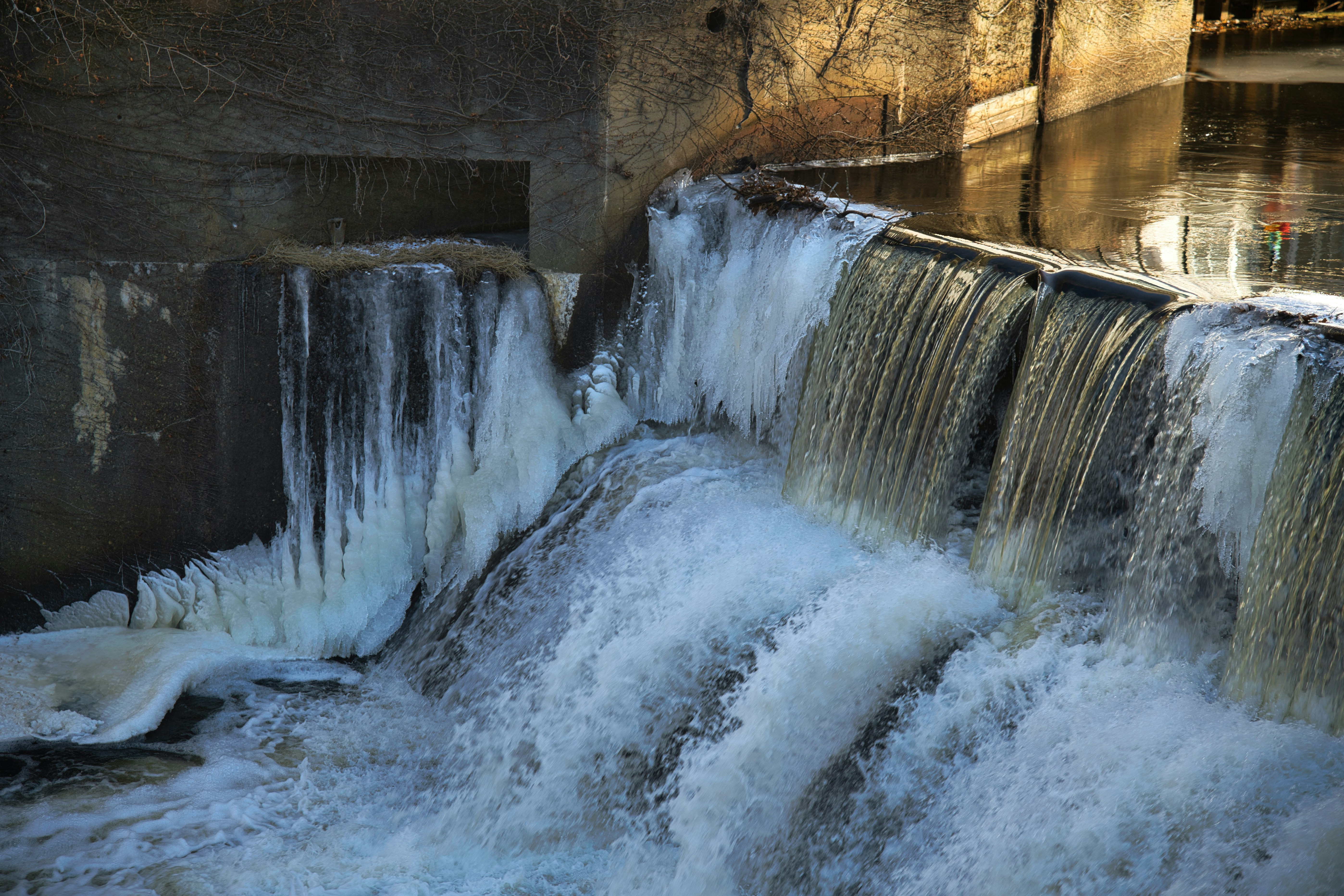 Frozen waterfall with rushing water in winter.