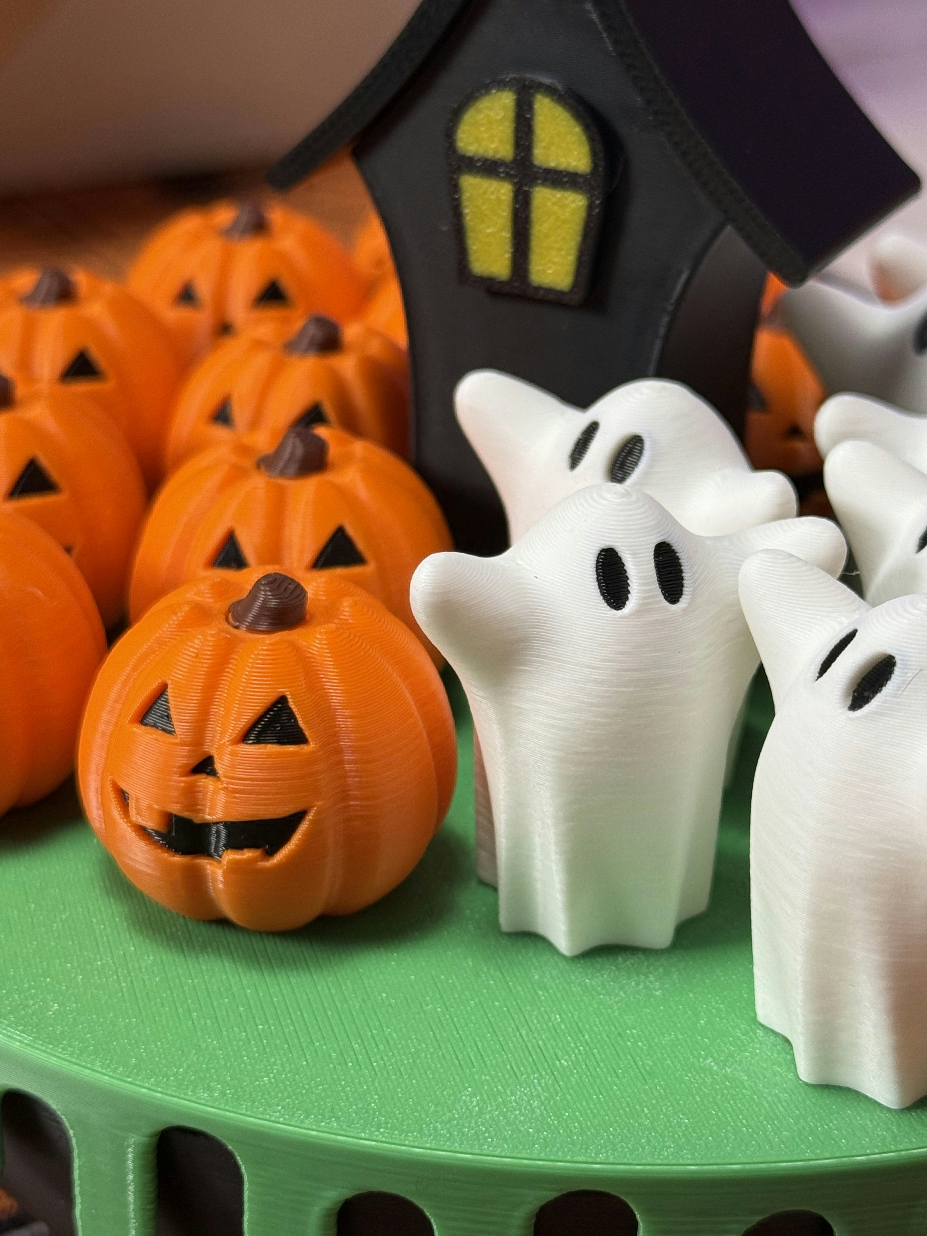 Halloween pumpkins and ghosts with a spooky house.