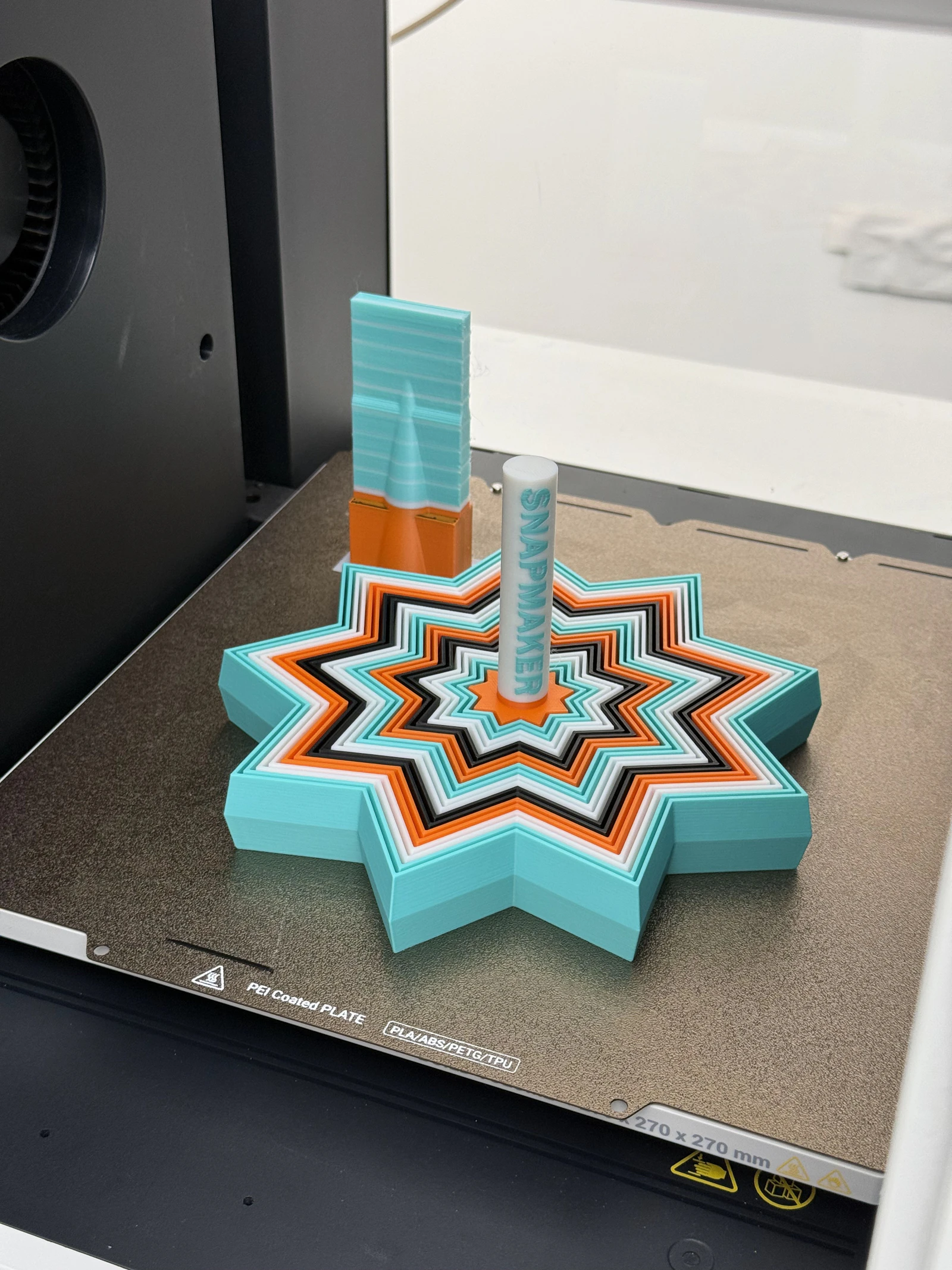 Multi-colour star shaped 3D print on a printer bed