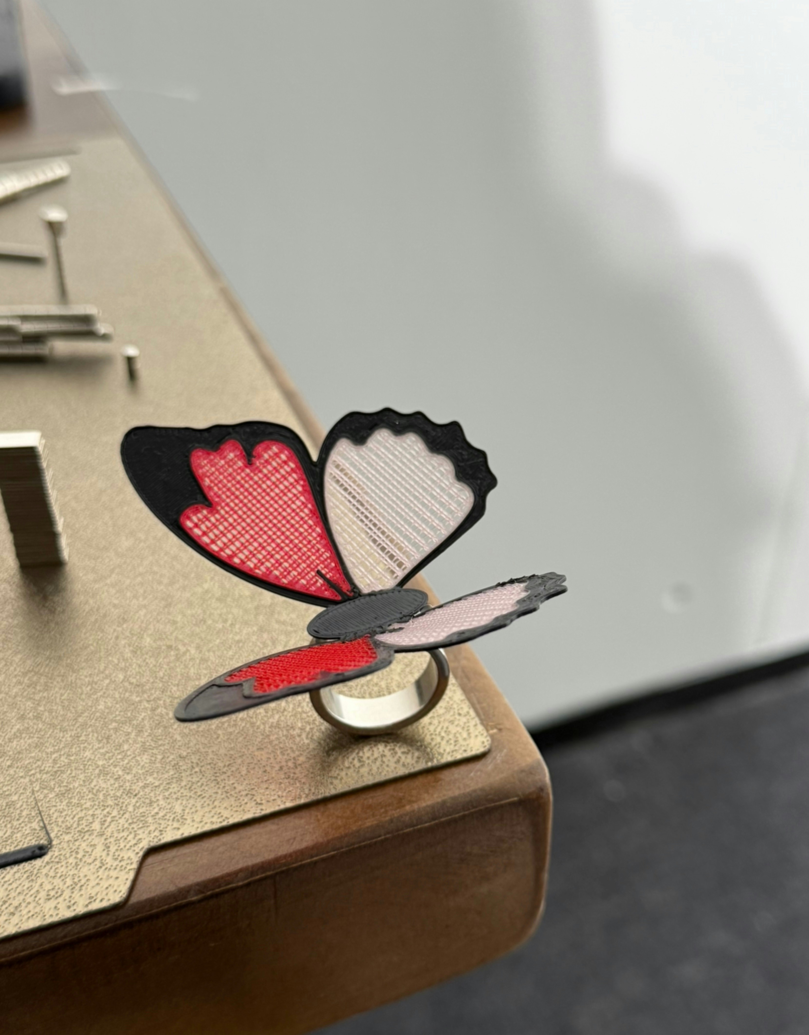 A butterfly ring with red and white wings.