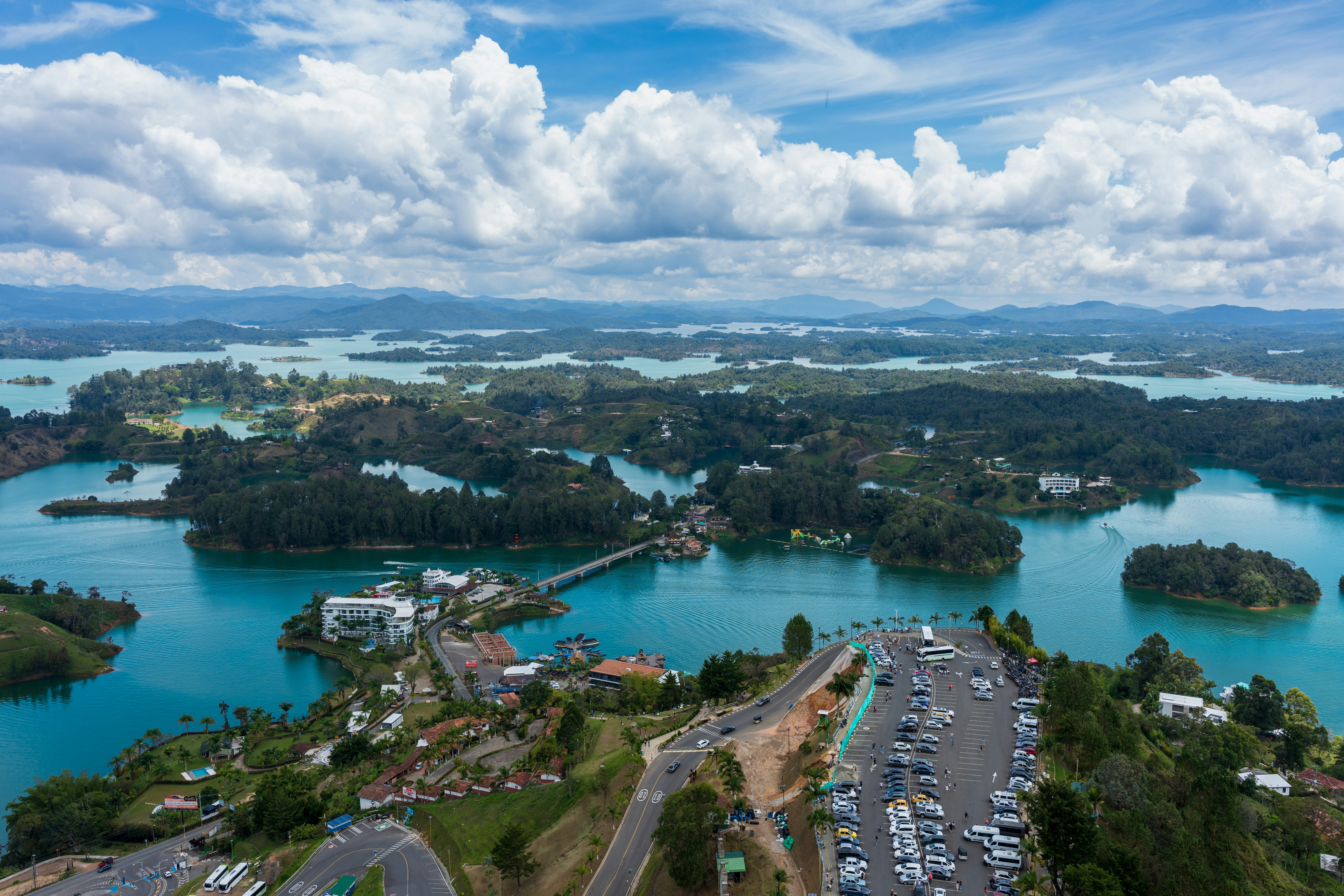 Aerial view of turquoise waters and green islands under clouds.