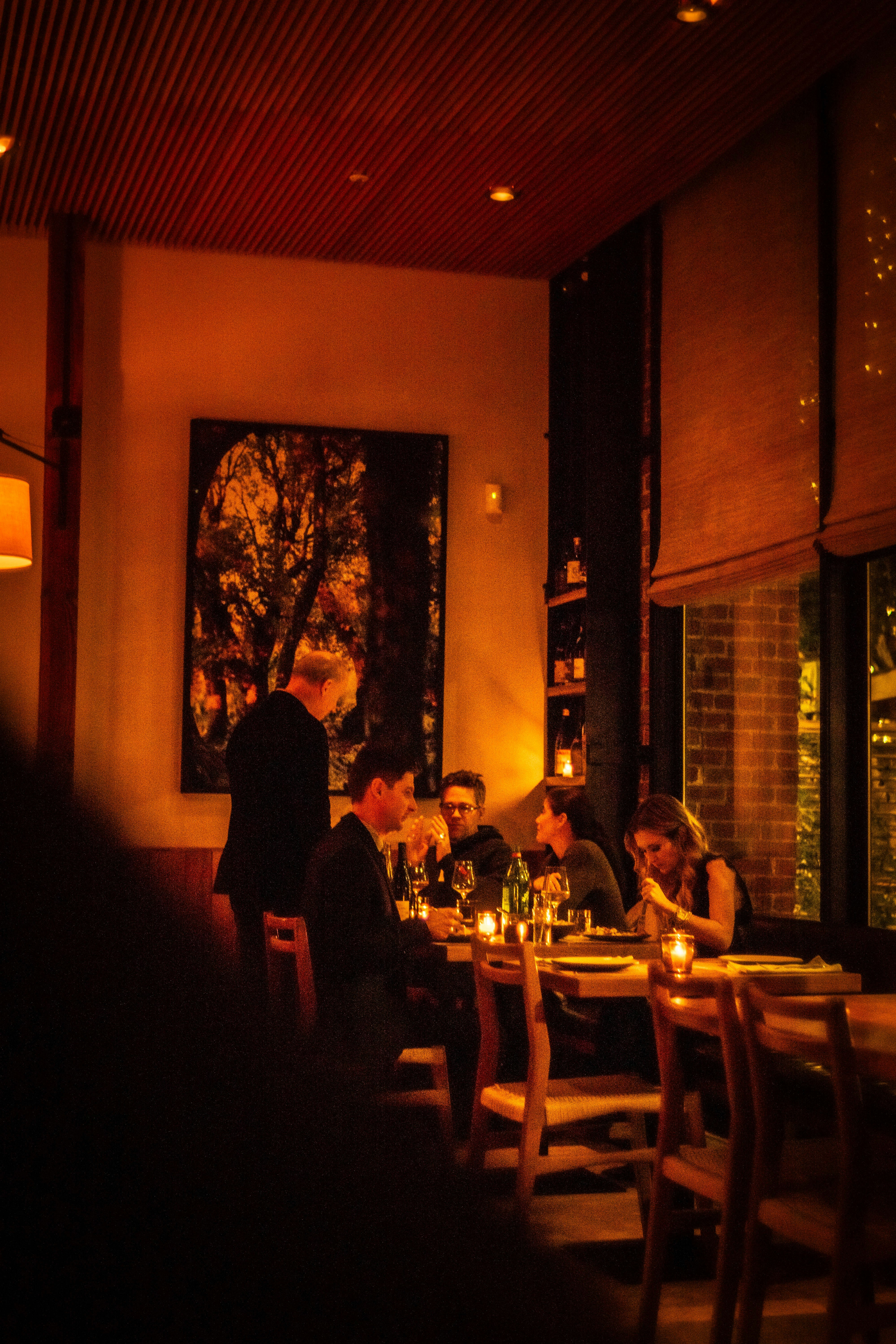 People dining at tables in a dimly lit restaurant