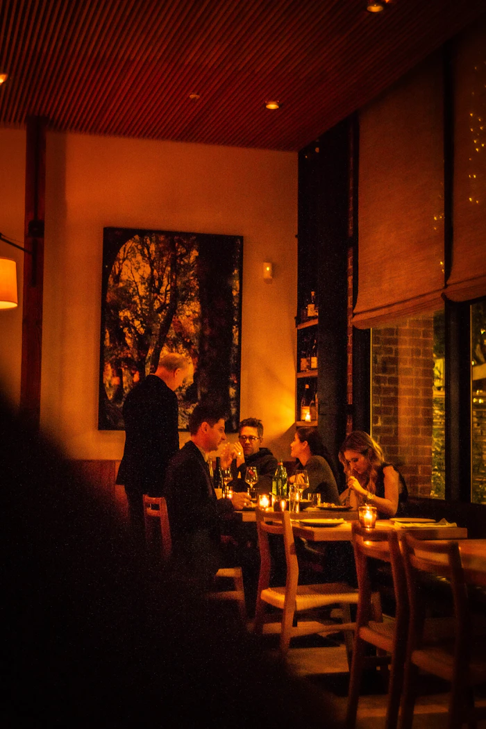 Guests at dinner in the warmly lit dining room