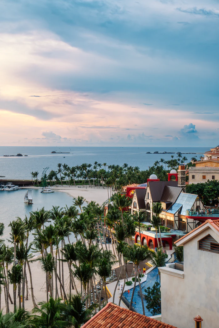 Tropical resort with palm trees overlooking the ocean at sunset, similar to Nassau's Cable Beach resort corridor