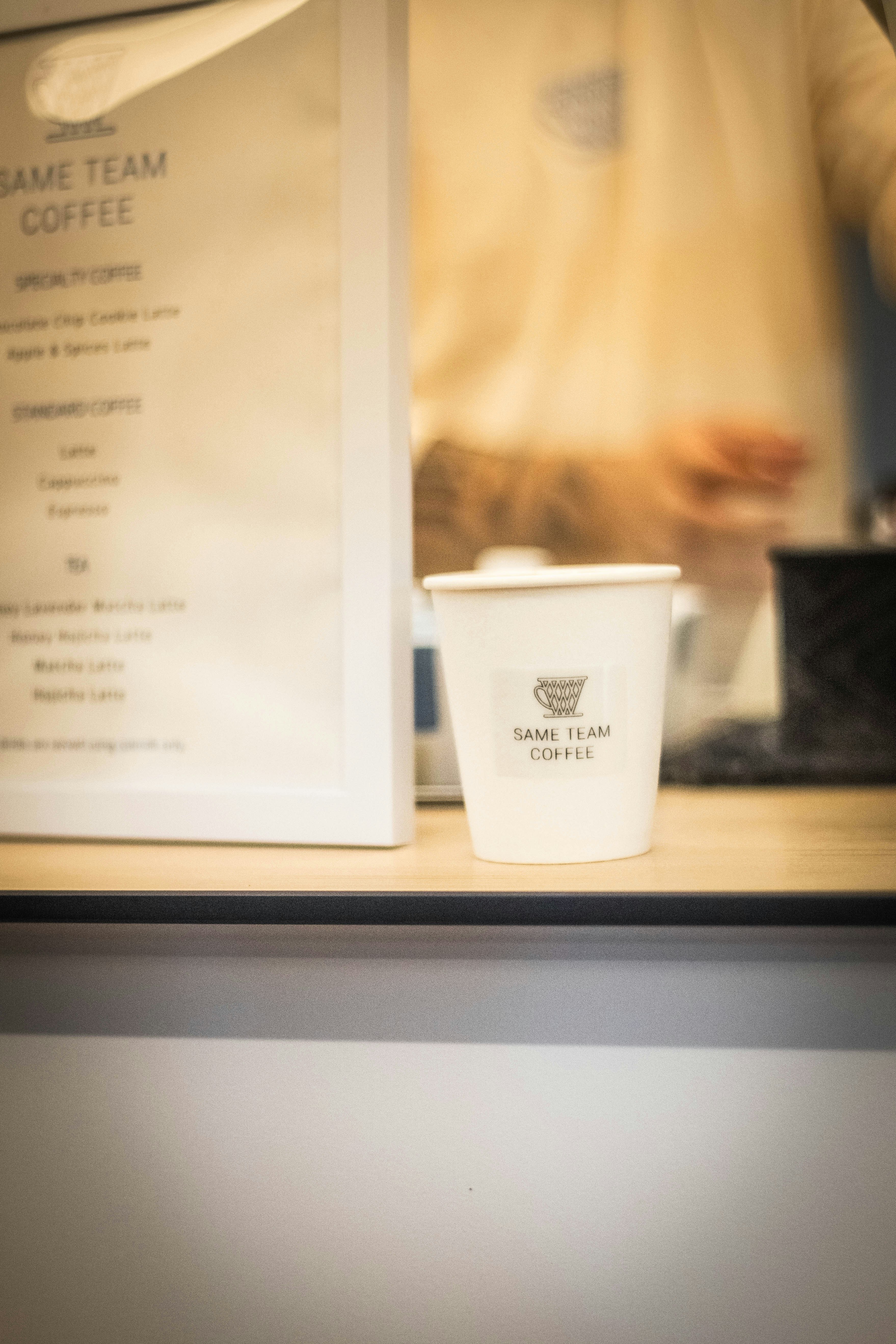 Coffee cup with logo next to menu
