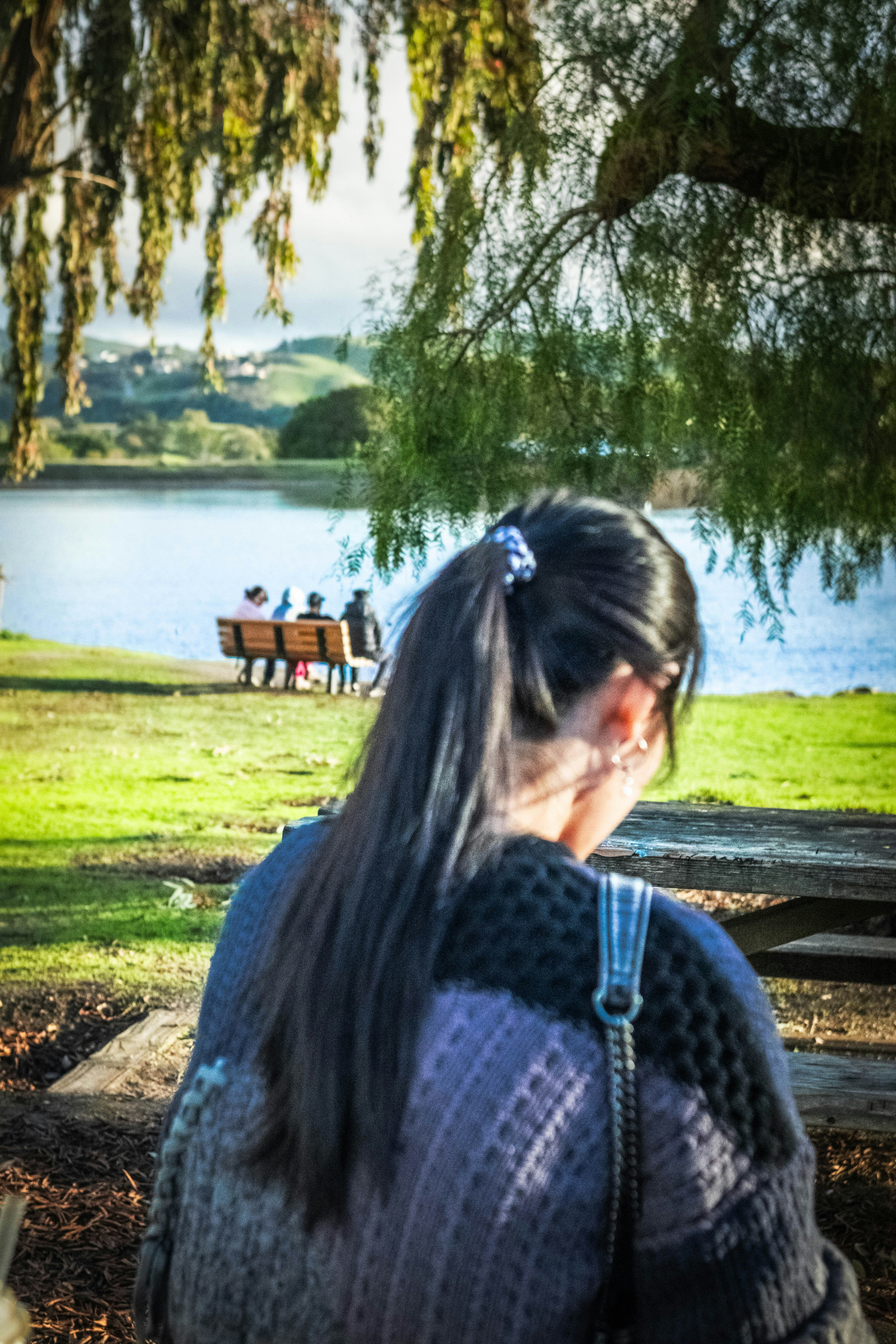 Woman in foreground looks at people on park bench