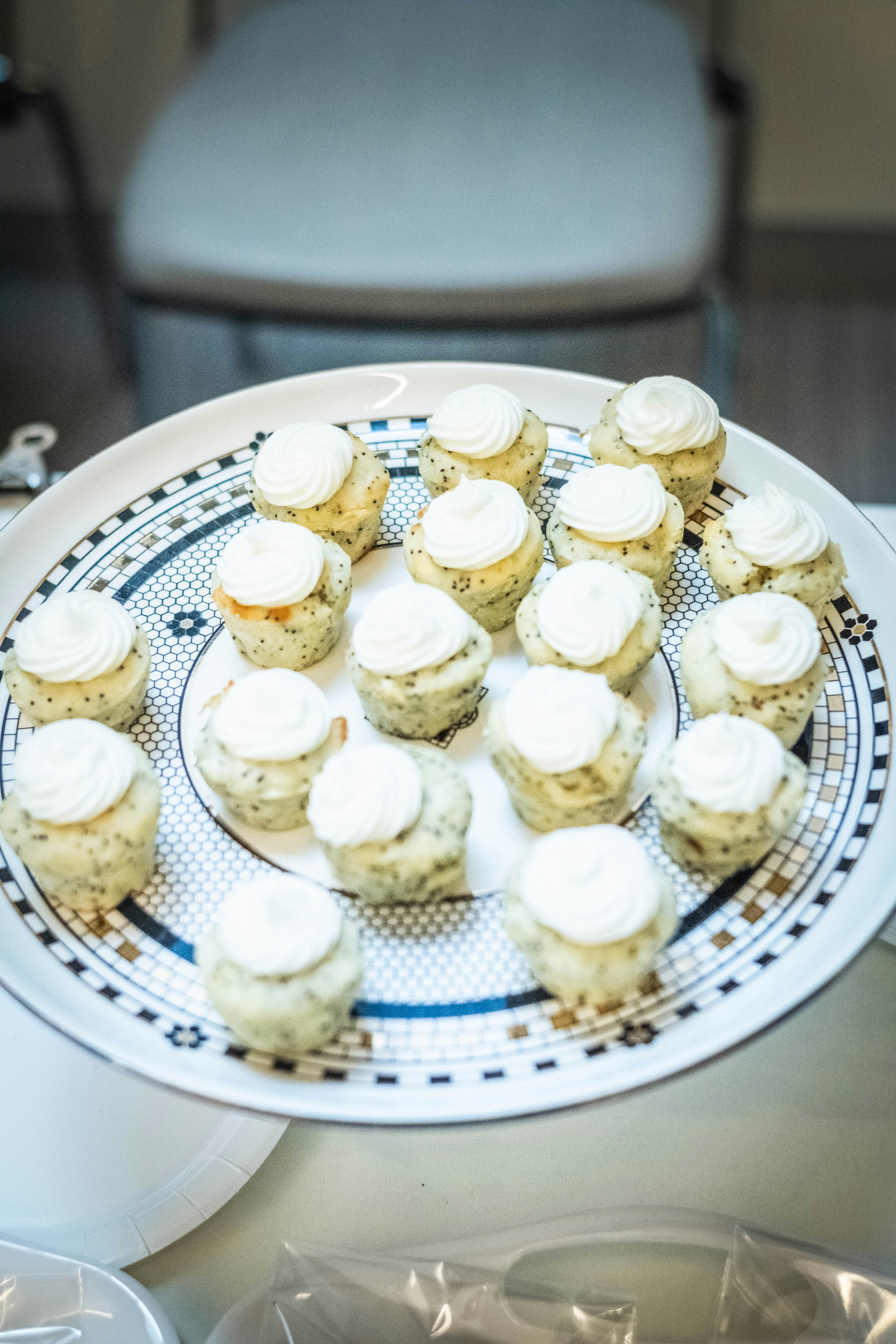 Small cupcakes with white frosting on a decorative plate