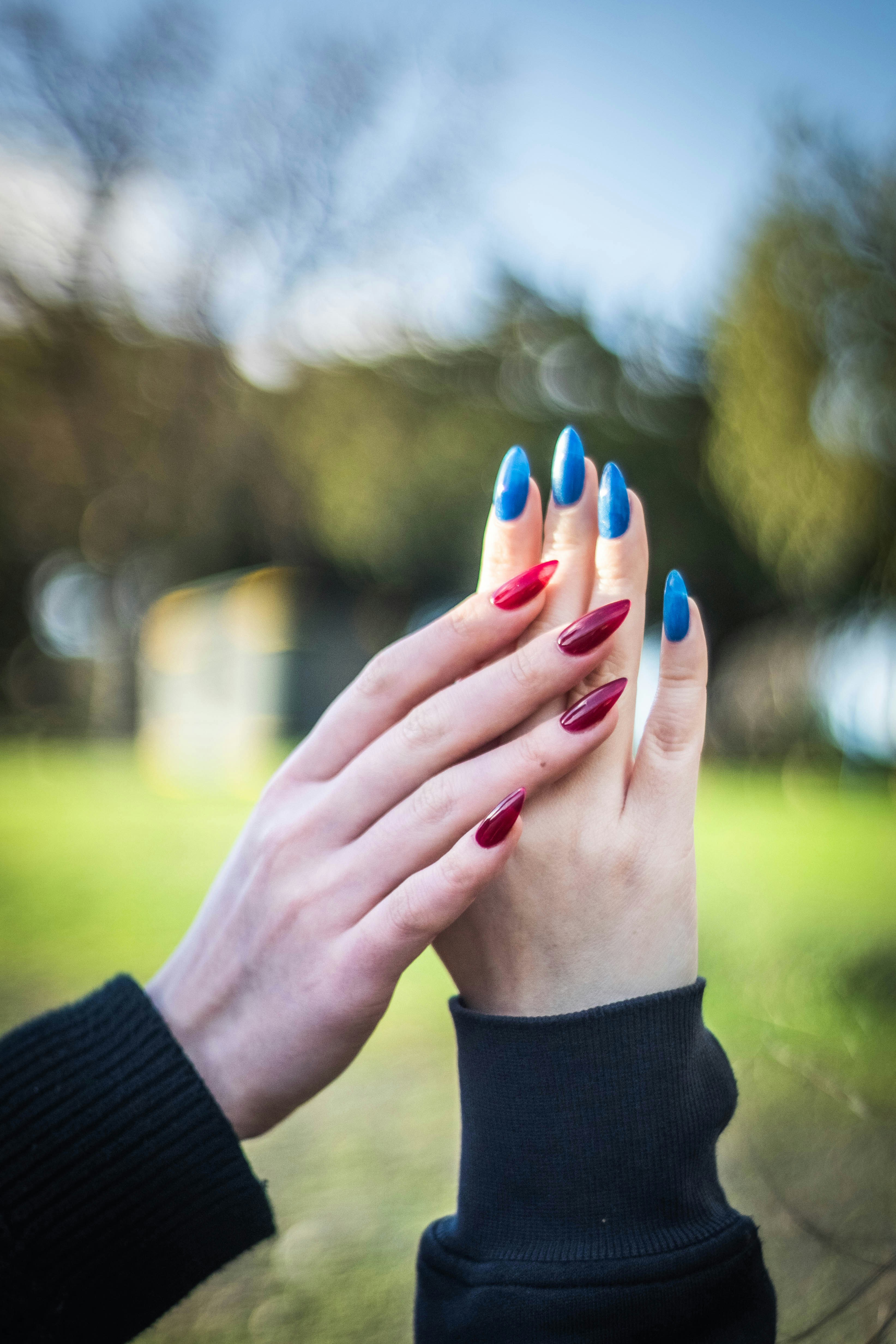 Hands with red and blue painted nails