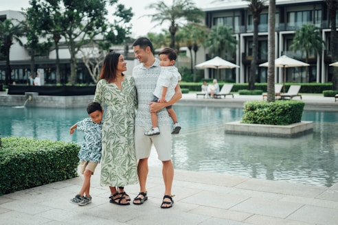 Family posing by the resort pool on a sunny day