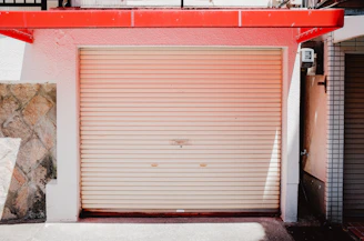 Closed metal garage door with red awning above.