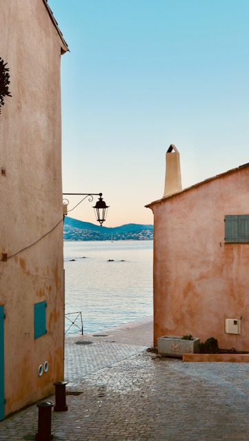 Buildings flank a street leading to the ocean at dawn.