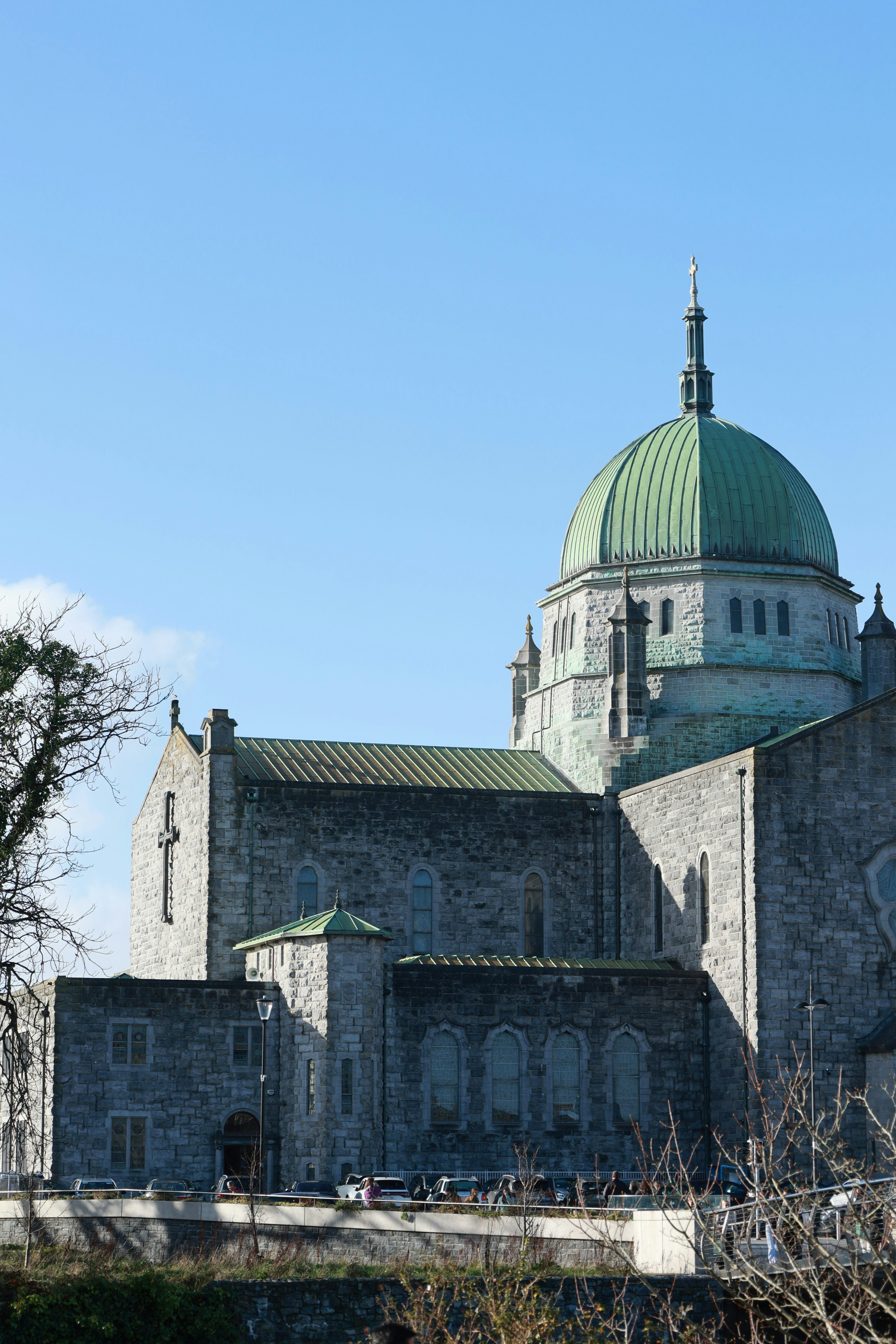 Stone cathedral with green dome under blue sky