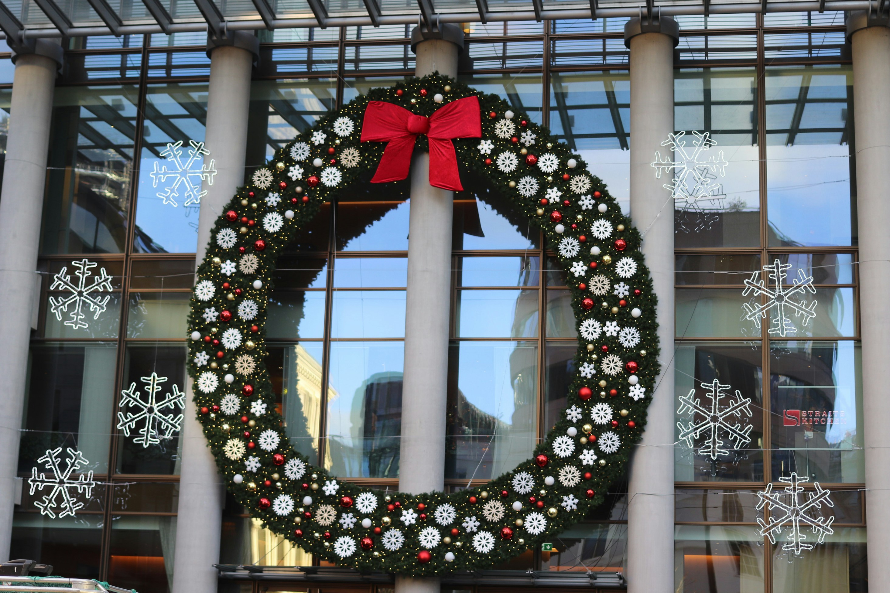 Large christmas wreath with red bow on building