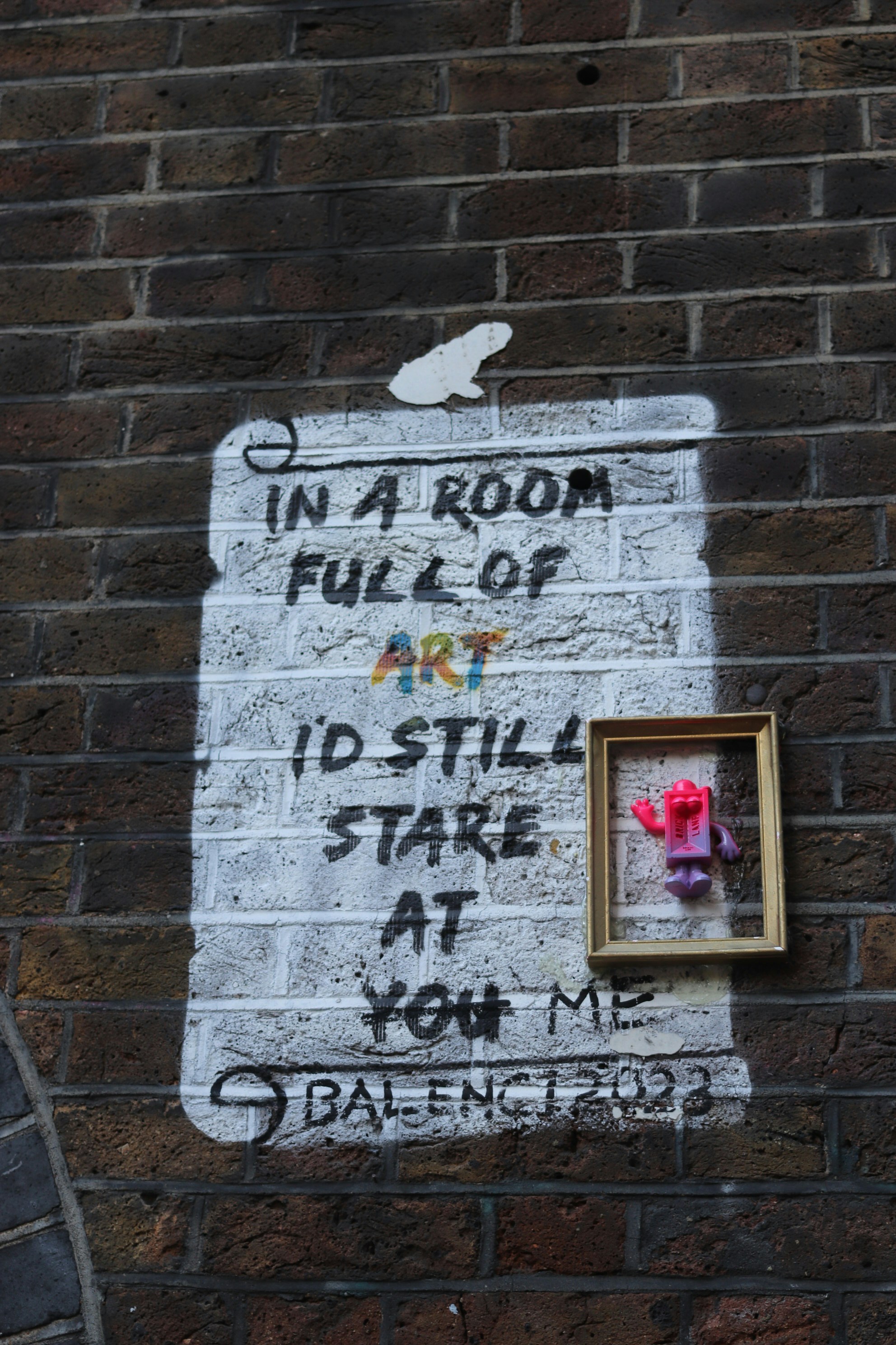 Graffiti on brick wall with framed figure