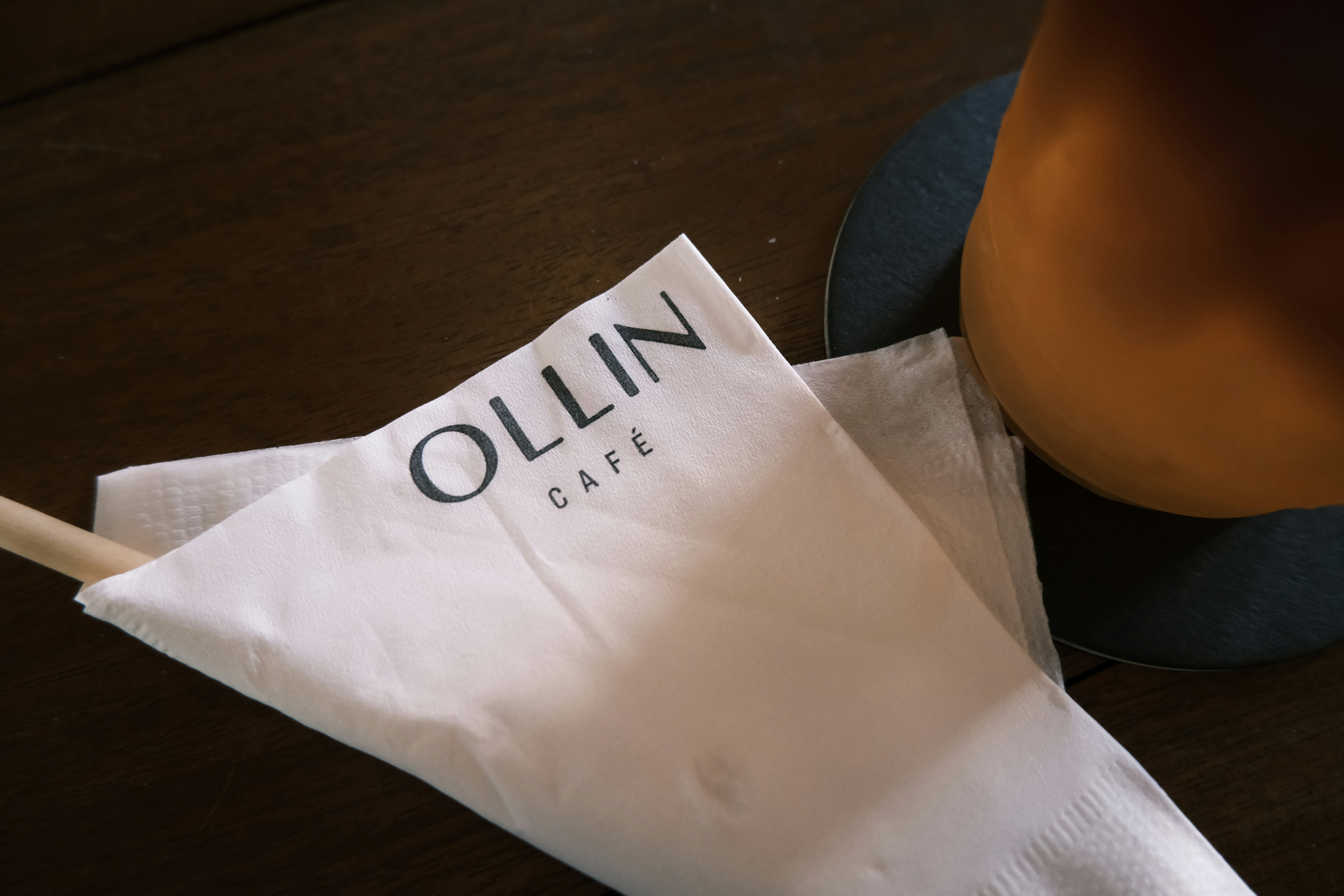 Logo du café Ollin sur une serviette blanche avec de la paille
